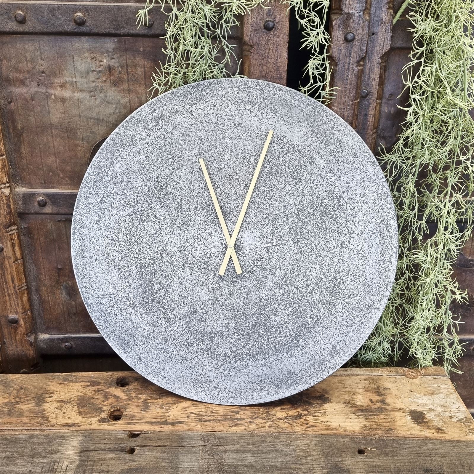 Wanduhr Rund Silber auf einem Holzhintergrund mit Pflanzen und einem Holztisch - Benoa