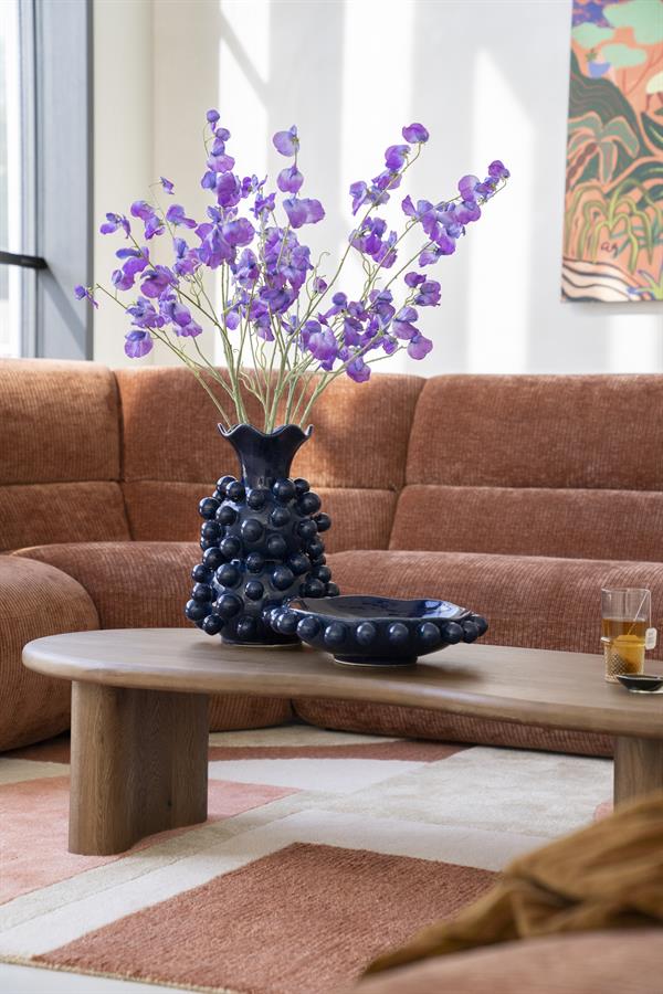 Schale Viro Blau mit lila Blumen und passender Vase auf einem Couchtisch aus Holz in einem Wohnzimmer - By-Boo