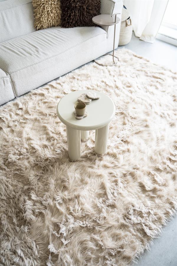 Der Beistelltisch Bloop steht auf einem Hochflorteppich, mit einem Sofa und Kissen im Hintergrund - By-Boo