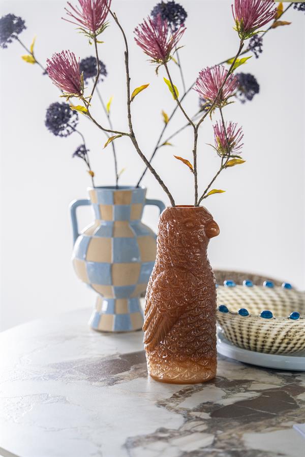 Die Vase Pico Caramel steht vorne rechts auf einem Marmortisch, mit einer karierten Vase dahinter - By-Boo