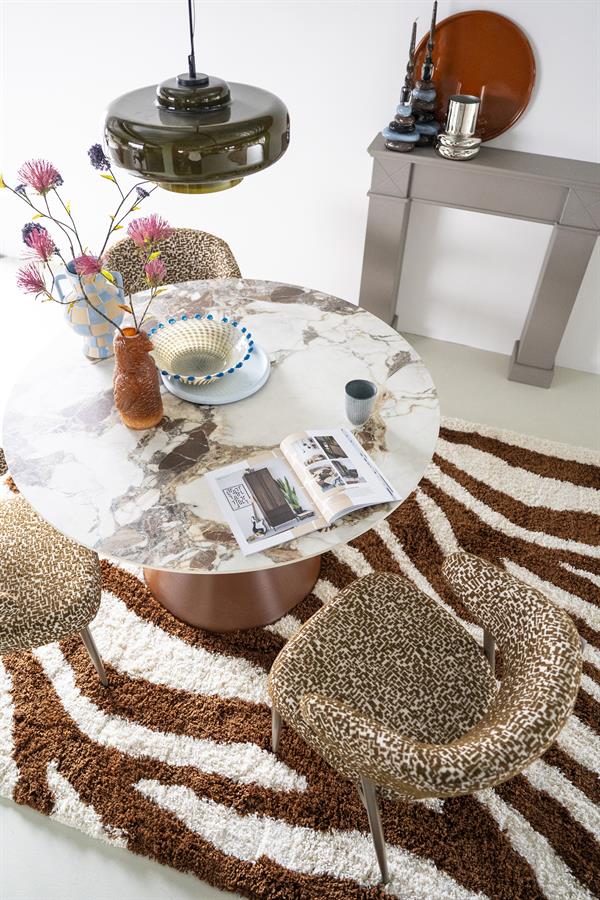 Der Esstisch Roka in einem modernen Interieur mit leopardgemusterten Stühlen und einem braun-weißen Teppich - By-Boo