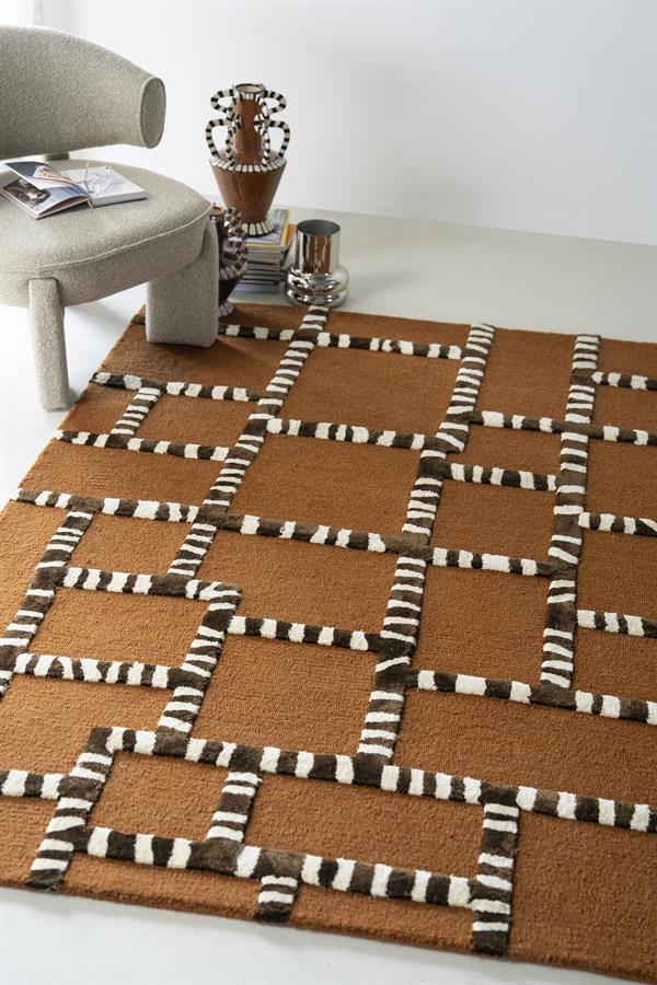 Teppich StripeScape Karamell in einer modernen Umgebung mit einem Stuhl und dekorativen Vasen - By-Boo