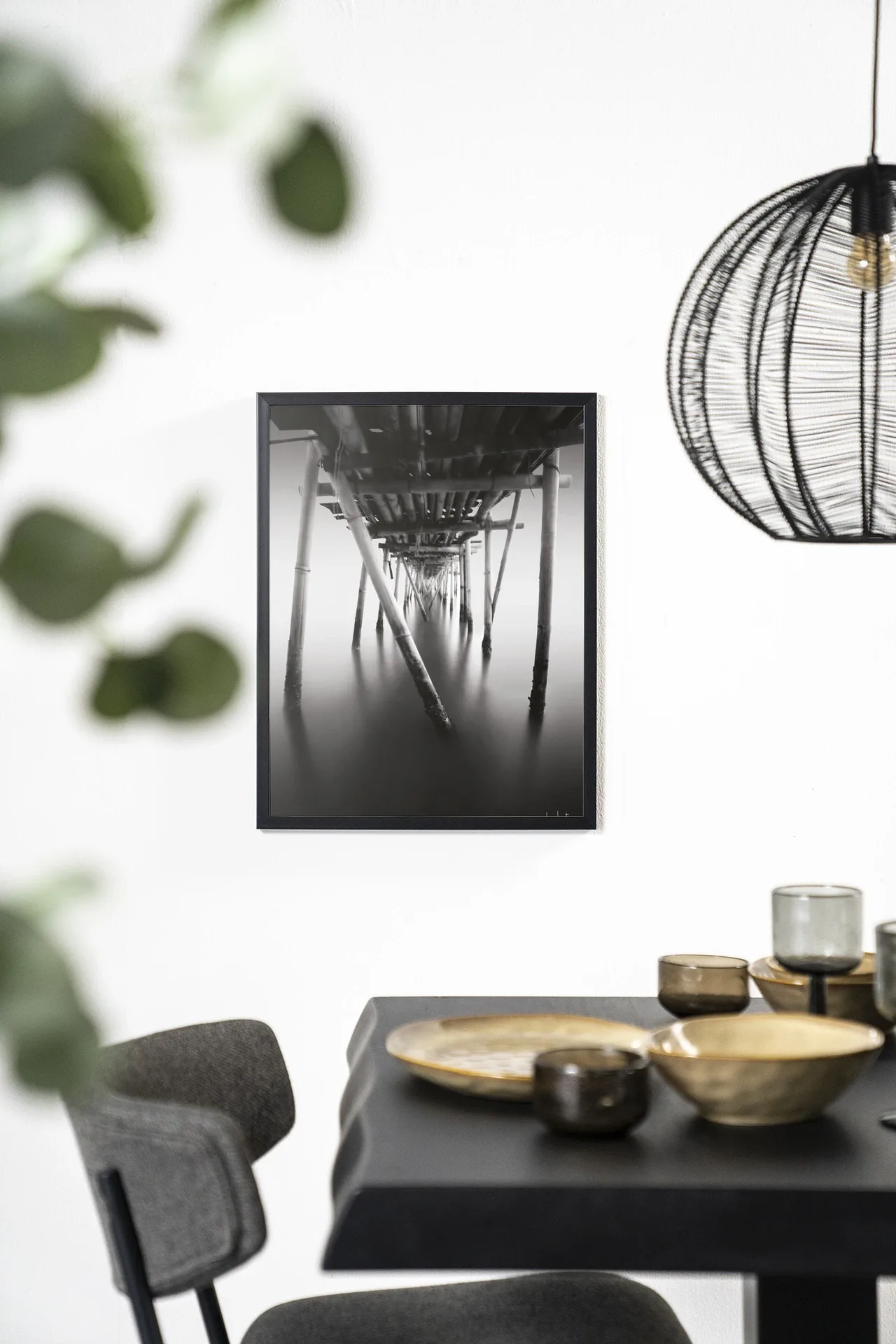 Wandkleed Underworld - Urban Cotton hangend aan een witte muur boven een zwarte tafel
