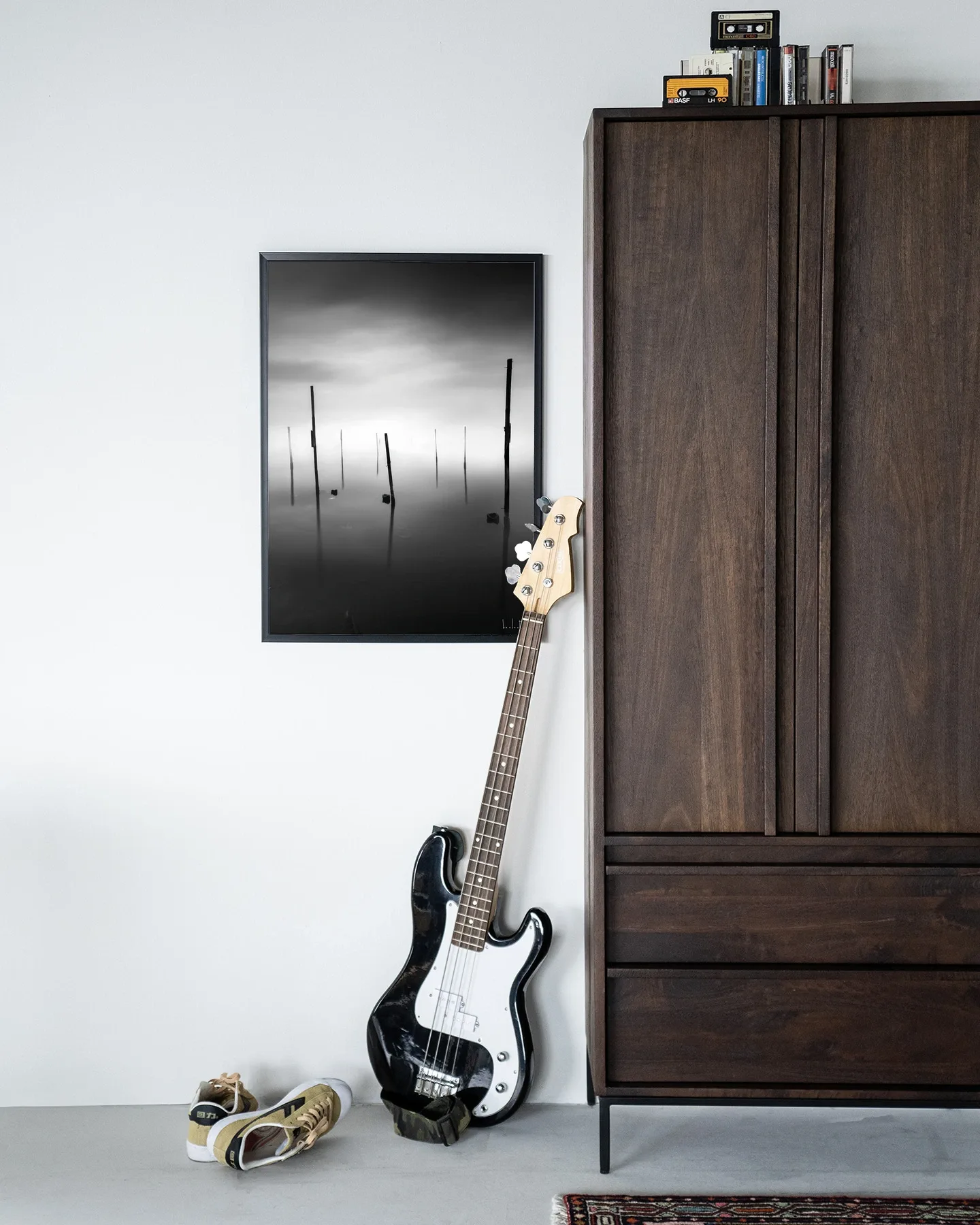 Wandteppich Fall In - Urban Cotton hängt an einer weißen Wand neben einem dunkelbraunen Schrank mit einer Bassgitarre davor