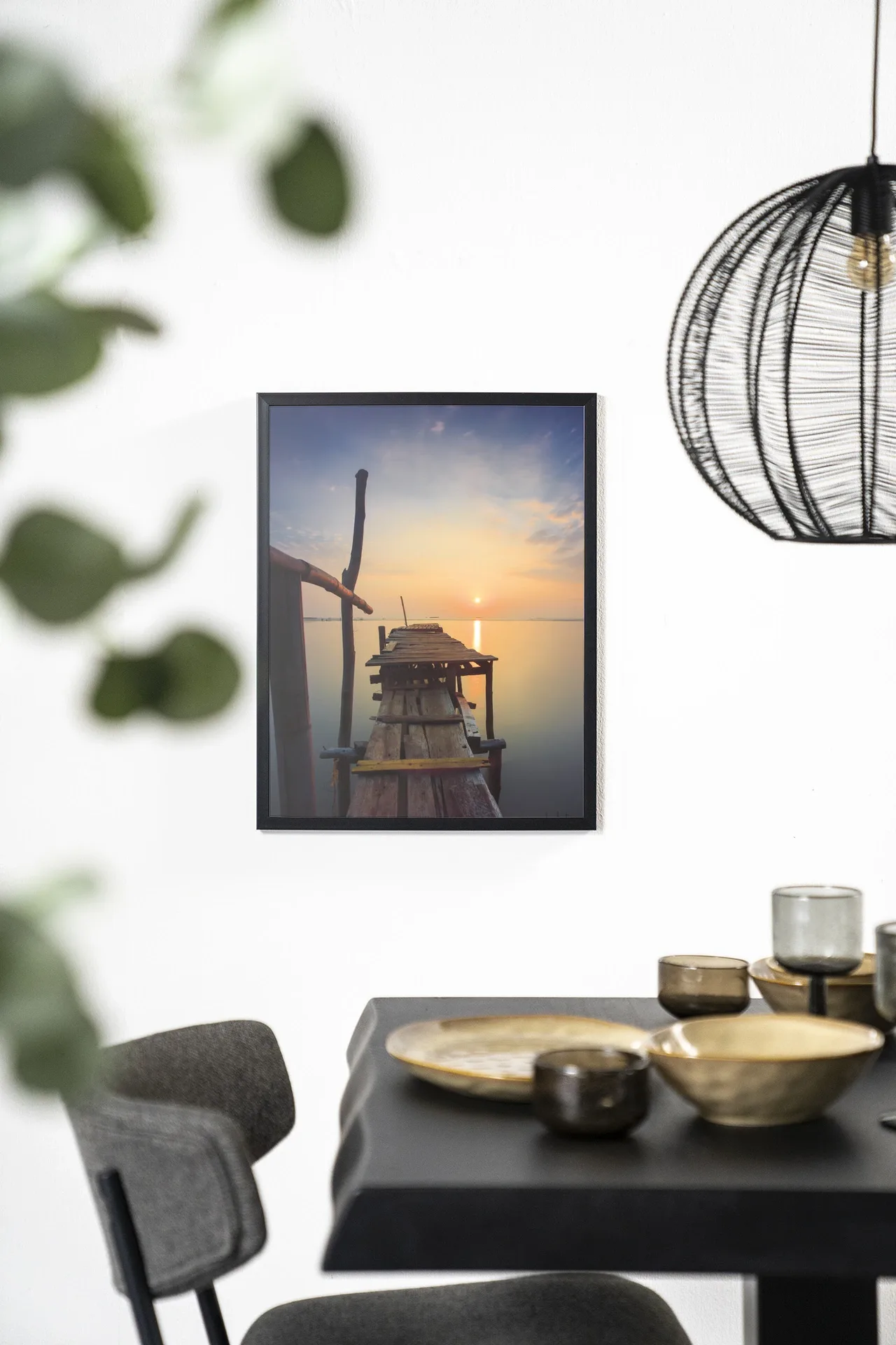 Wandteppich Sun shy cirebon - Urban Cotton hängt an einer weißen Wand über einem schwarzen Tisch