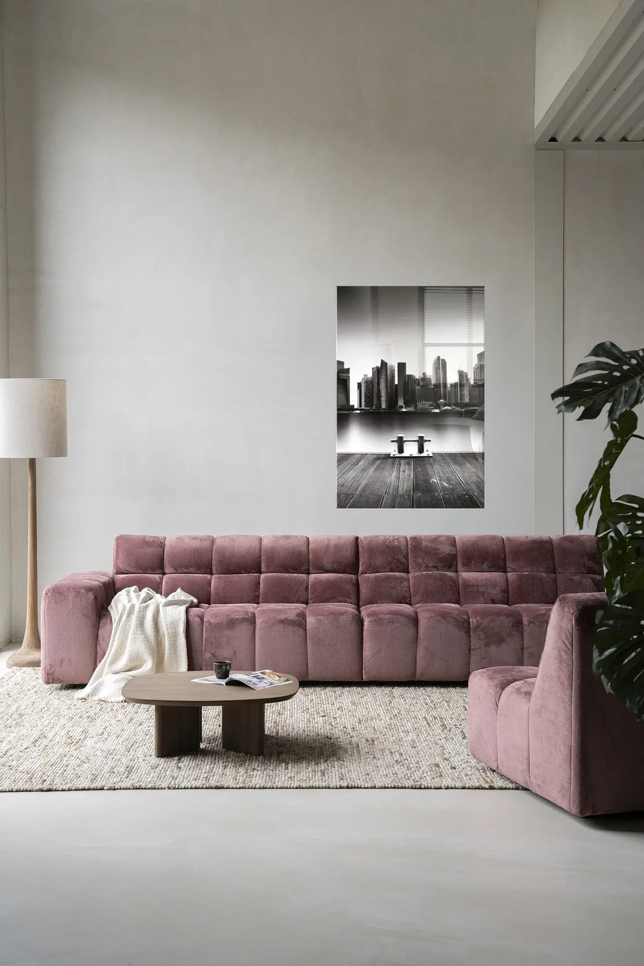 Der Wandteppich Momentarily Silent - Urban Cotton hängt über einem rosa Sofa in einem modernen Wohnzimmer
