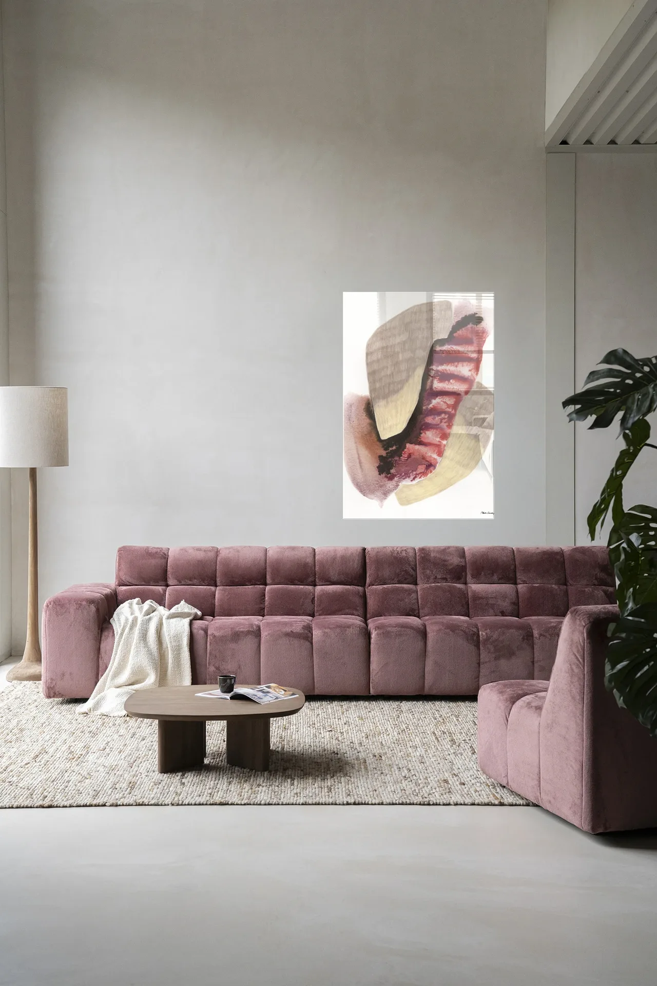 Wandkleed Embrace van Urban Cotton hangend boven een roze bank in een moderne woonkamer