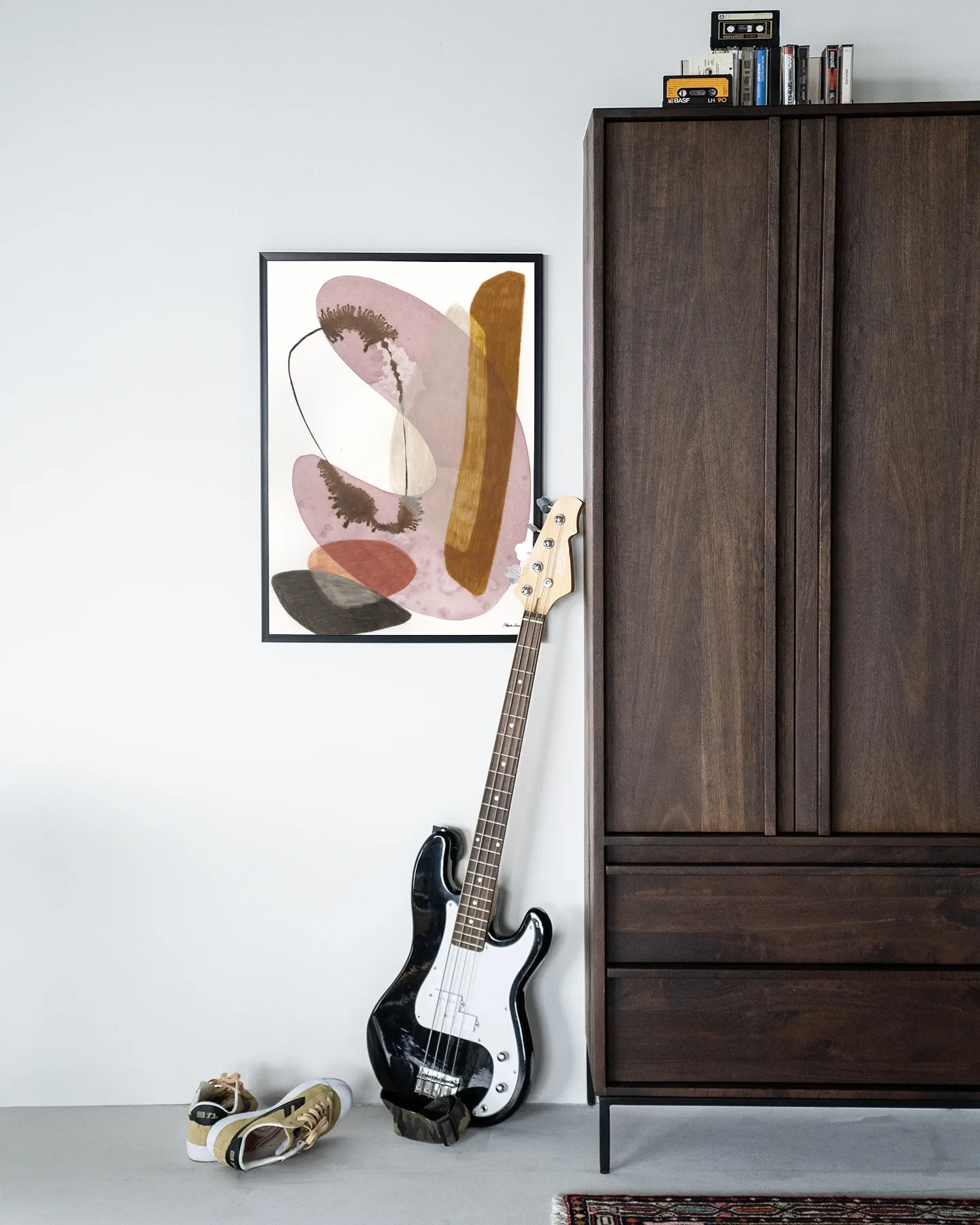 Wandteppich Balance - Urban Cotton hängt an einer weißen Wand neben einem Holzschrank und einem Bass