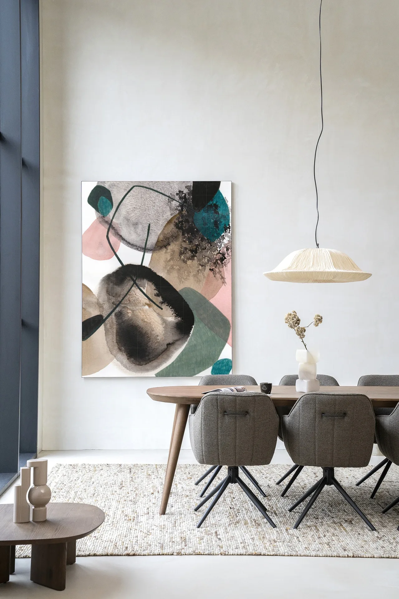 Wandteppich Splash - Urban Cotton hängt an einer weißen Wand über einem Esstisch mit Stühlen