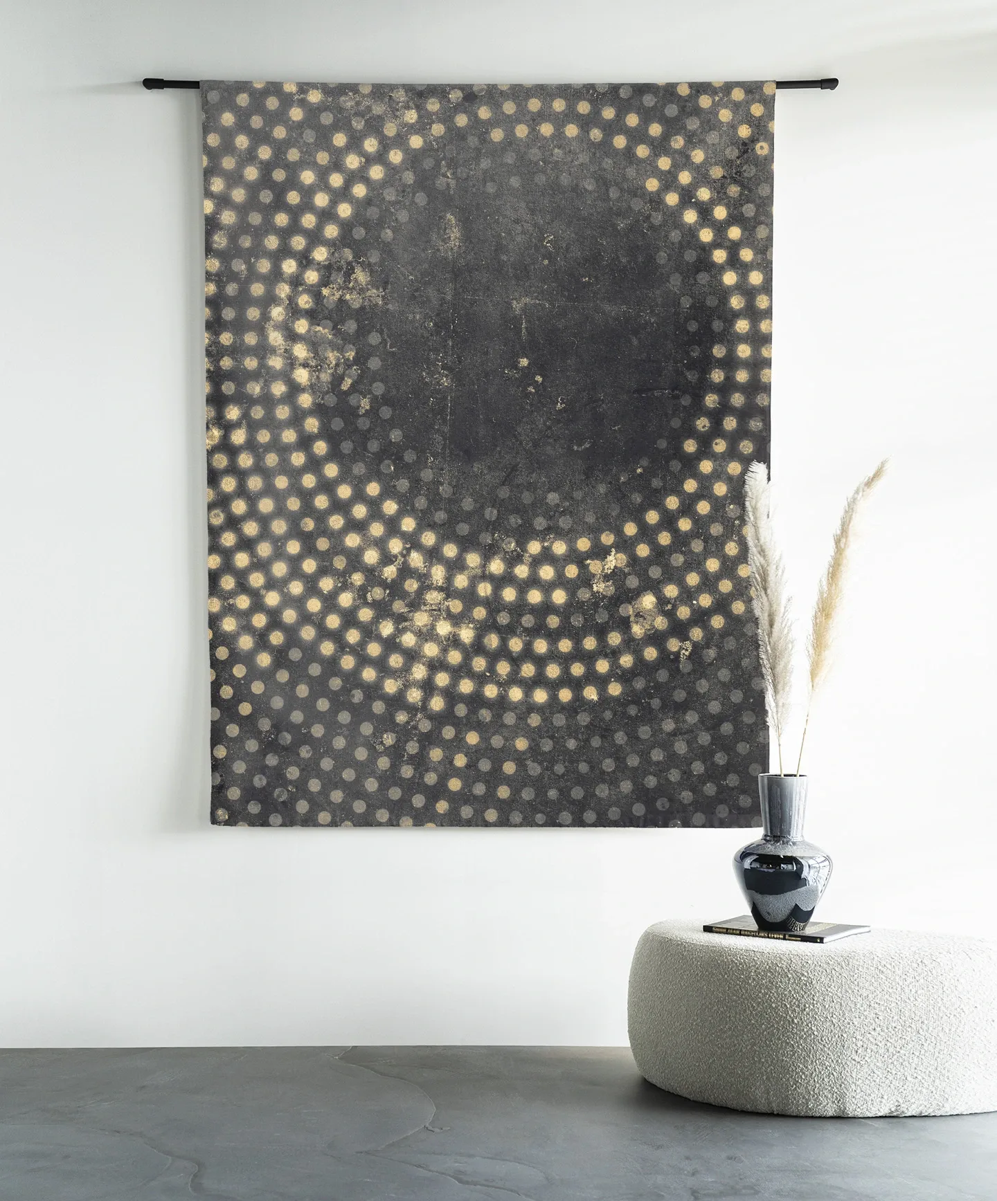 Wandbehang Cala - Urban Cotton hängt an einer schwarzen Stange über einem weißen Hocker mit Vase und Federn