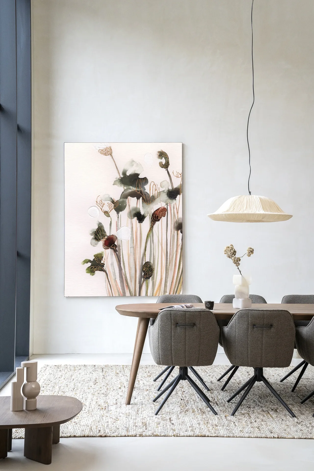 Wandbehang Pastel Flowers 2 hängt an einer hellen Wand über einem Holzesstisch mit Stoffstühlen - Urban Cotton