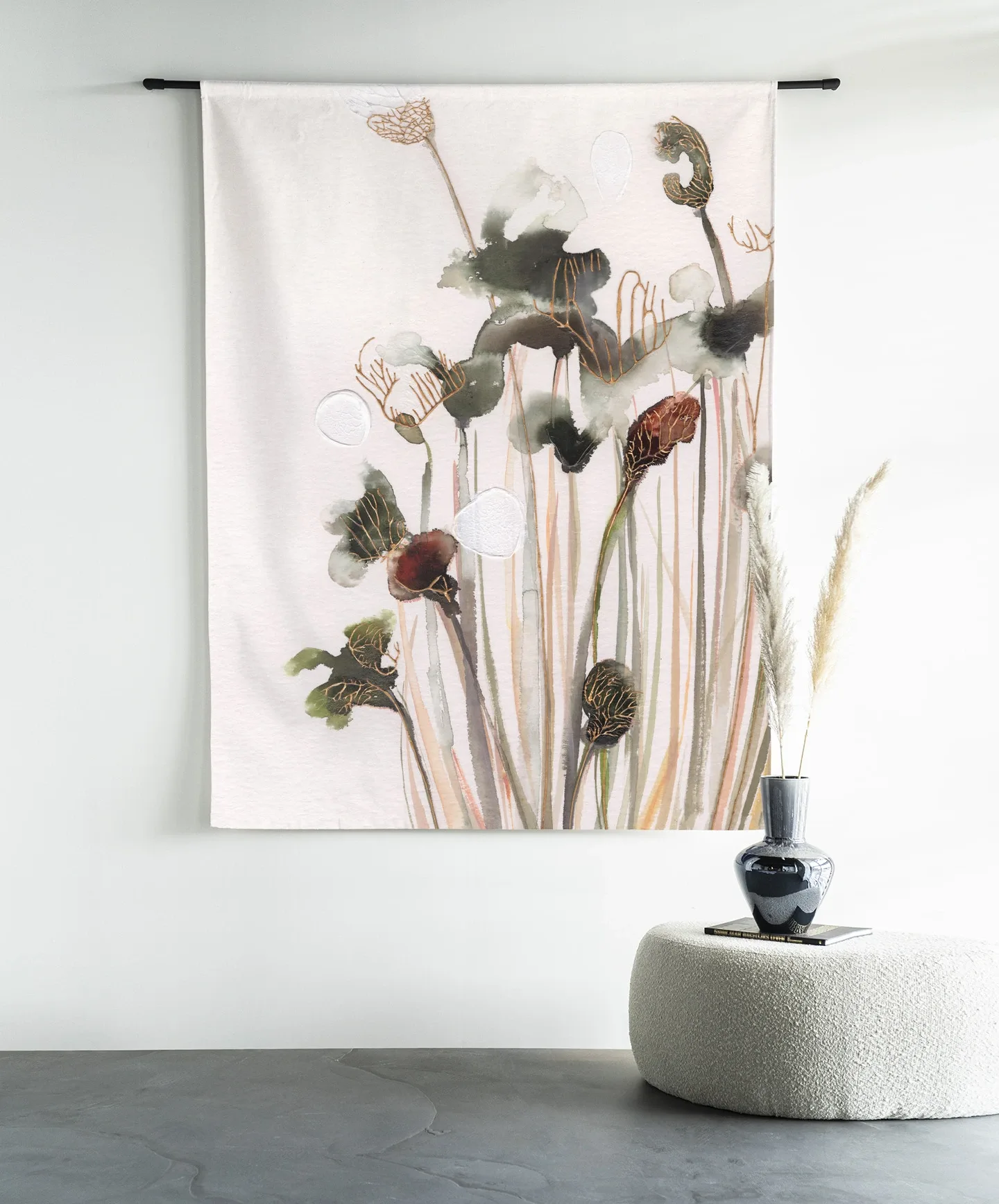 Wandbehang Pastel Flowers 2 hängt an einer schwarzen Stange über einem weißen Hocker mit einer Vase und Pampasgras - Urban Cotton