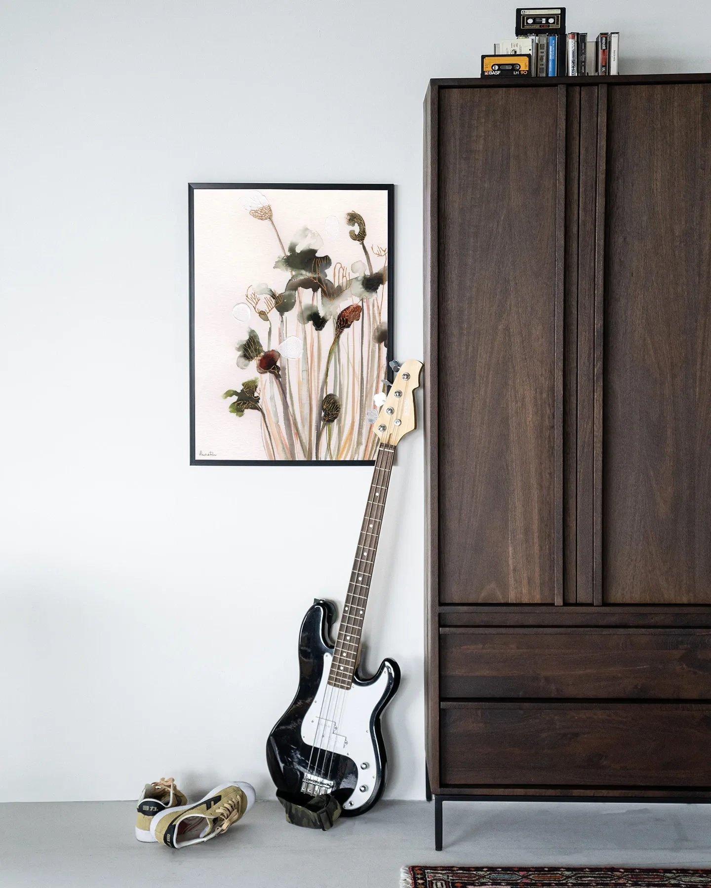 Wandbehang Pastel Flowers 2 hängt an einer weißen Wand neben einem dunkelbraunen Schrank mit einer Bassgitarre davor - Urban Cotton