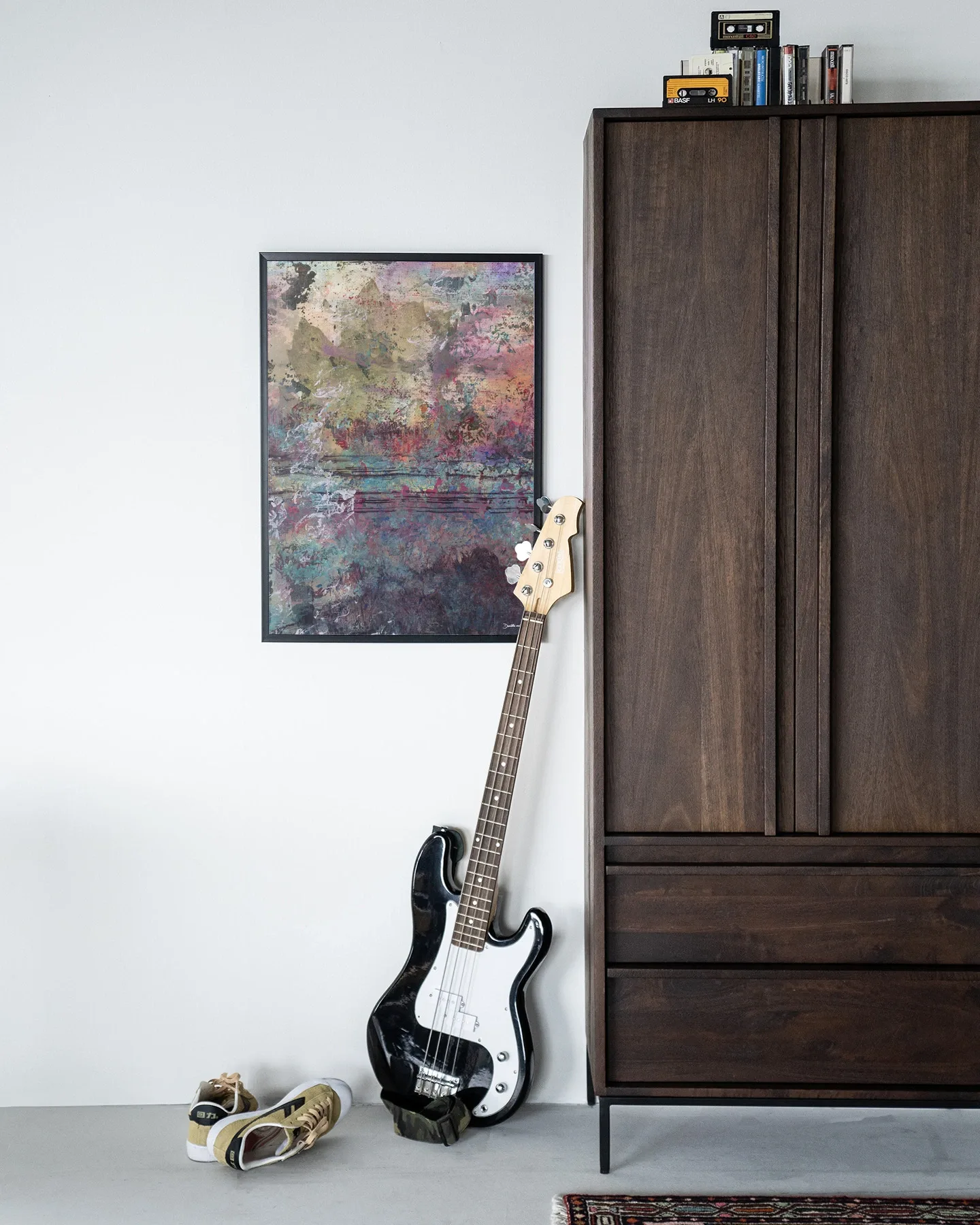 De Art print Birch Tree Autumn 2 - Urban Cotton hangt aan een witte muur naast een donkerbruine kast, met een basgitaar en schoenen ervoor
