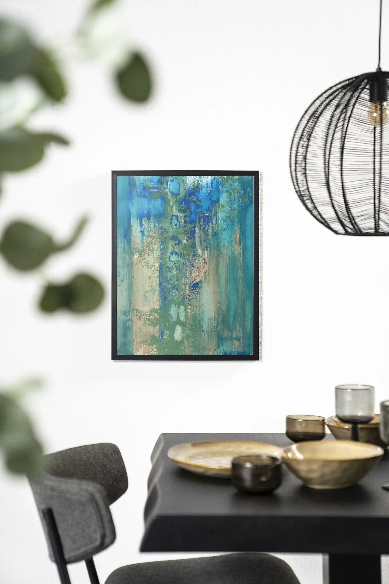 Der Art Print Blue Green Abstract - Urban Cotton hängt an einer weißen Wand über einem schwarzen Tisch