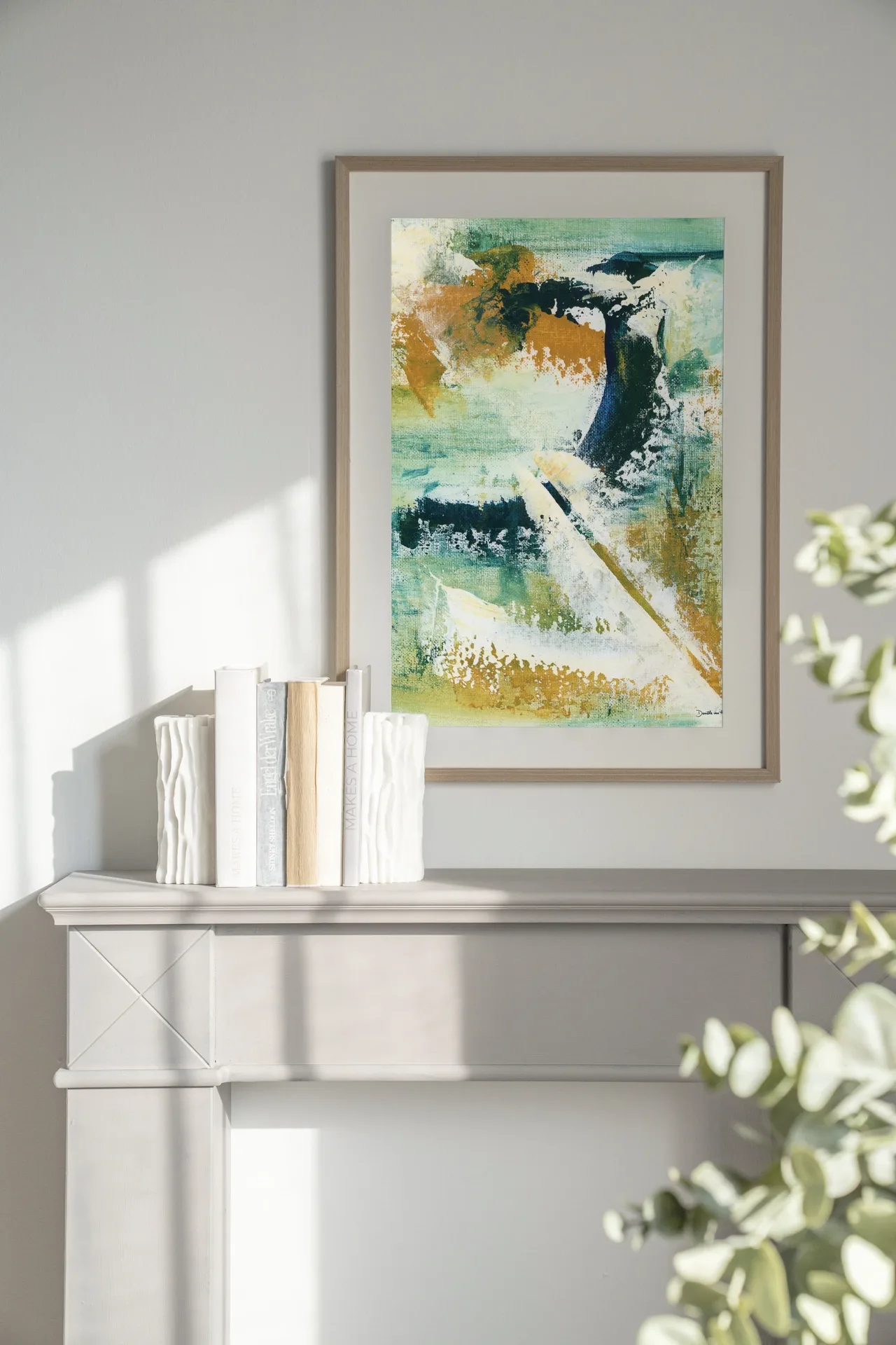 Art Print Mood - Urban Cotton in einem Rahmen über einem Kaminsims mit Büchern und Vasen