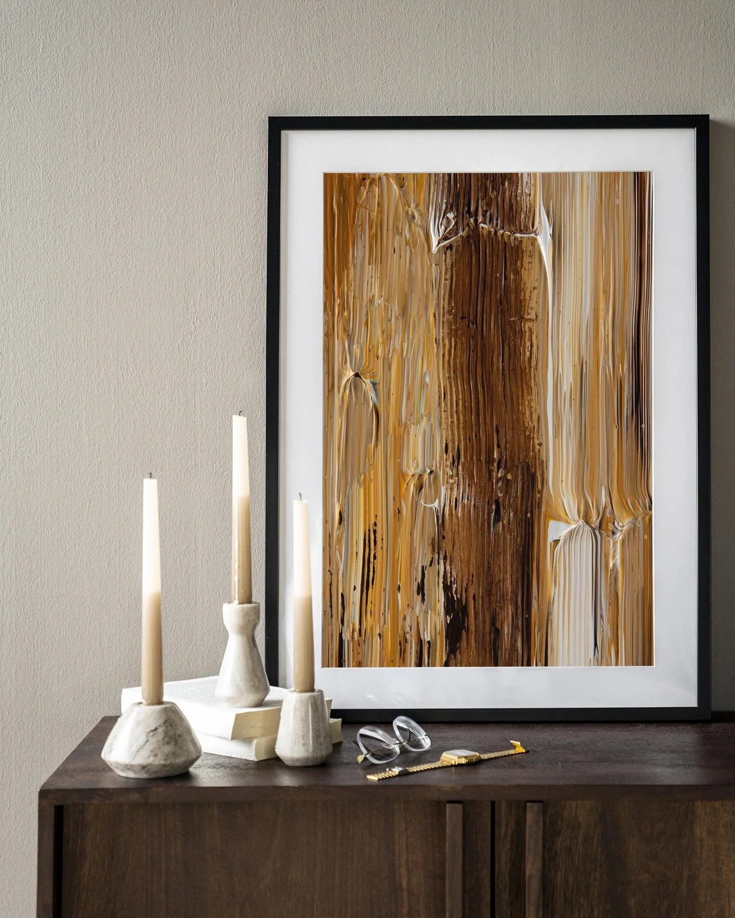 Wandteppich Fluid - Urban Cotton in einem Rahmen, stehend auf einem dunkelbraunen Sideboard mit Kerzen und einer Brille