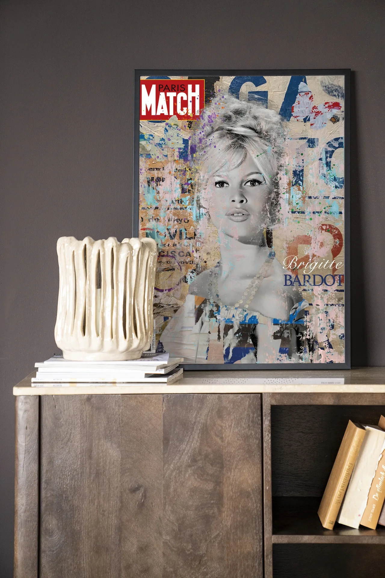 Wandteppich Brigitte - Urban Cotton hängt an einer dunkelgrauen Wand, mit einer cremefarbenen Vase und Büchern auf einem Holzschrank