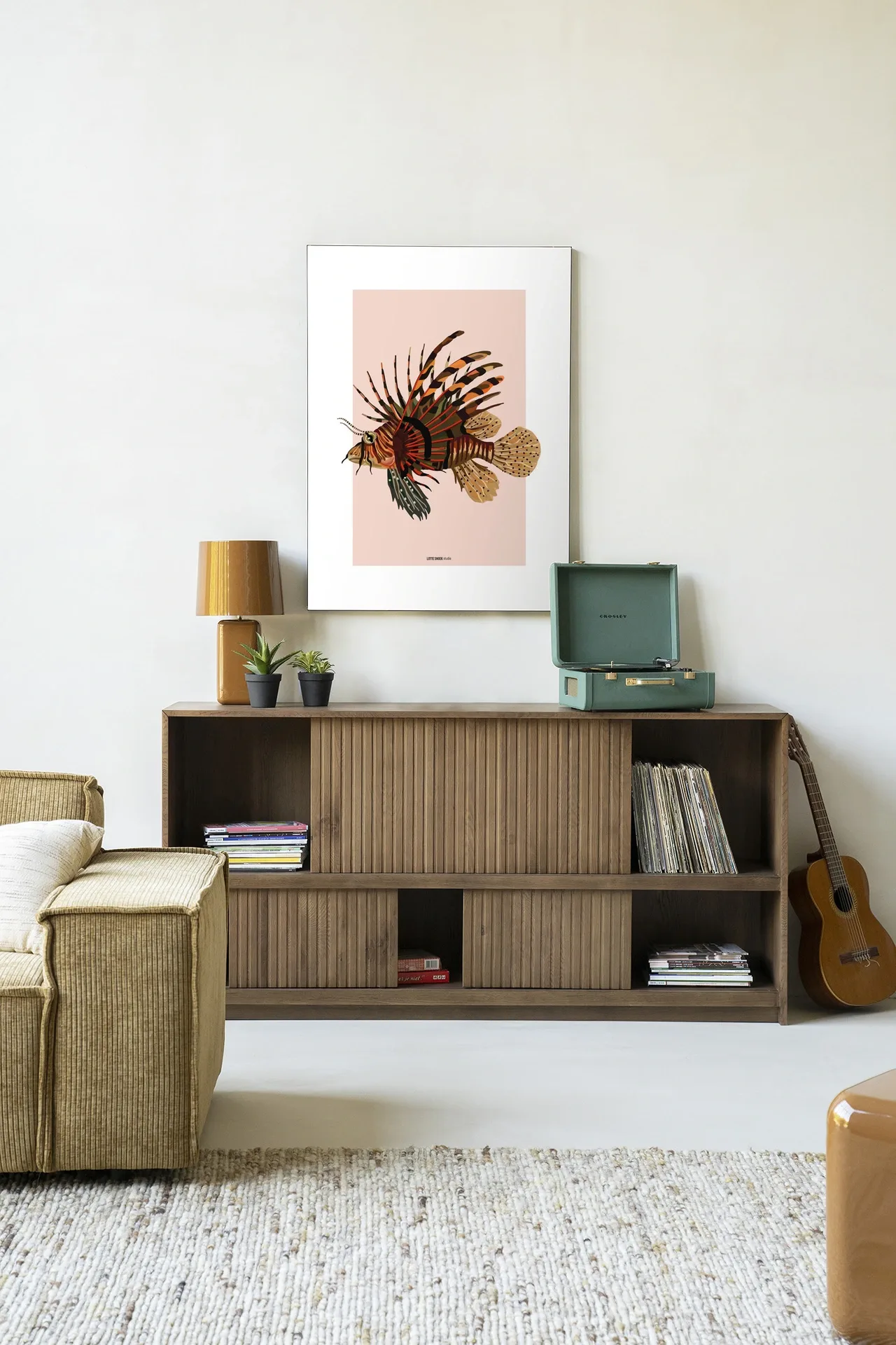 Art print Lio - Urban Cotton aan een witte muur boven een houten dressoir met decoratie