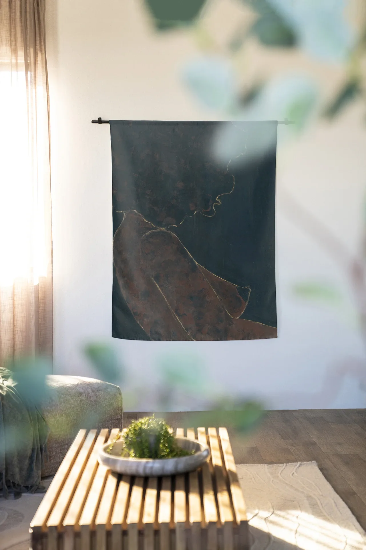 Wandteppich Cococure - Urban Cotton hängt an einer schwarzen Stange in einem hellen Wohnzimmer mit einem Couchtisch aus Holz