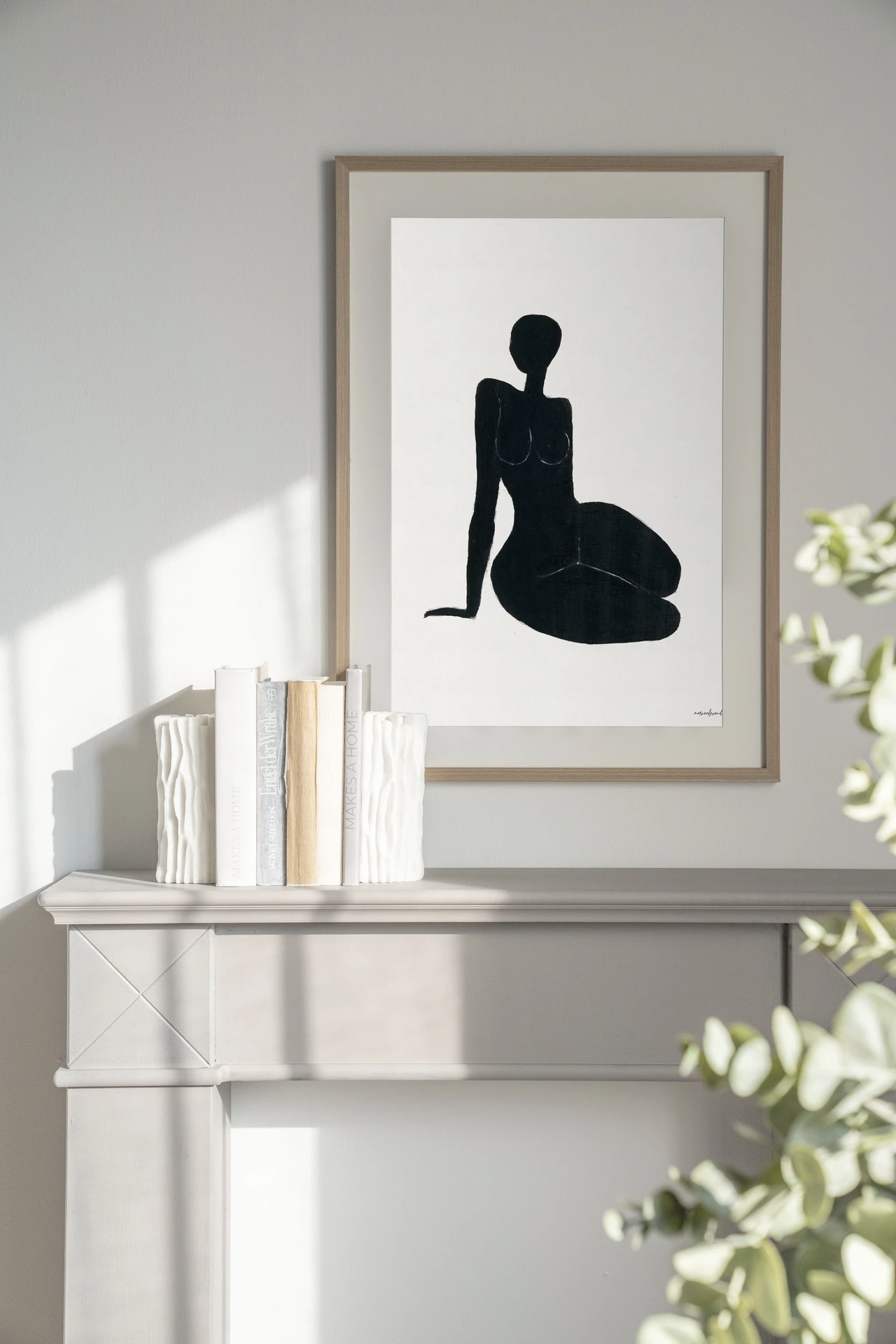 Een Art print International Woman - Urban Cotton in een houten lijst boven een ladekast