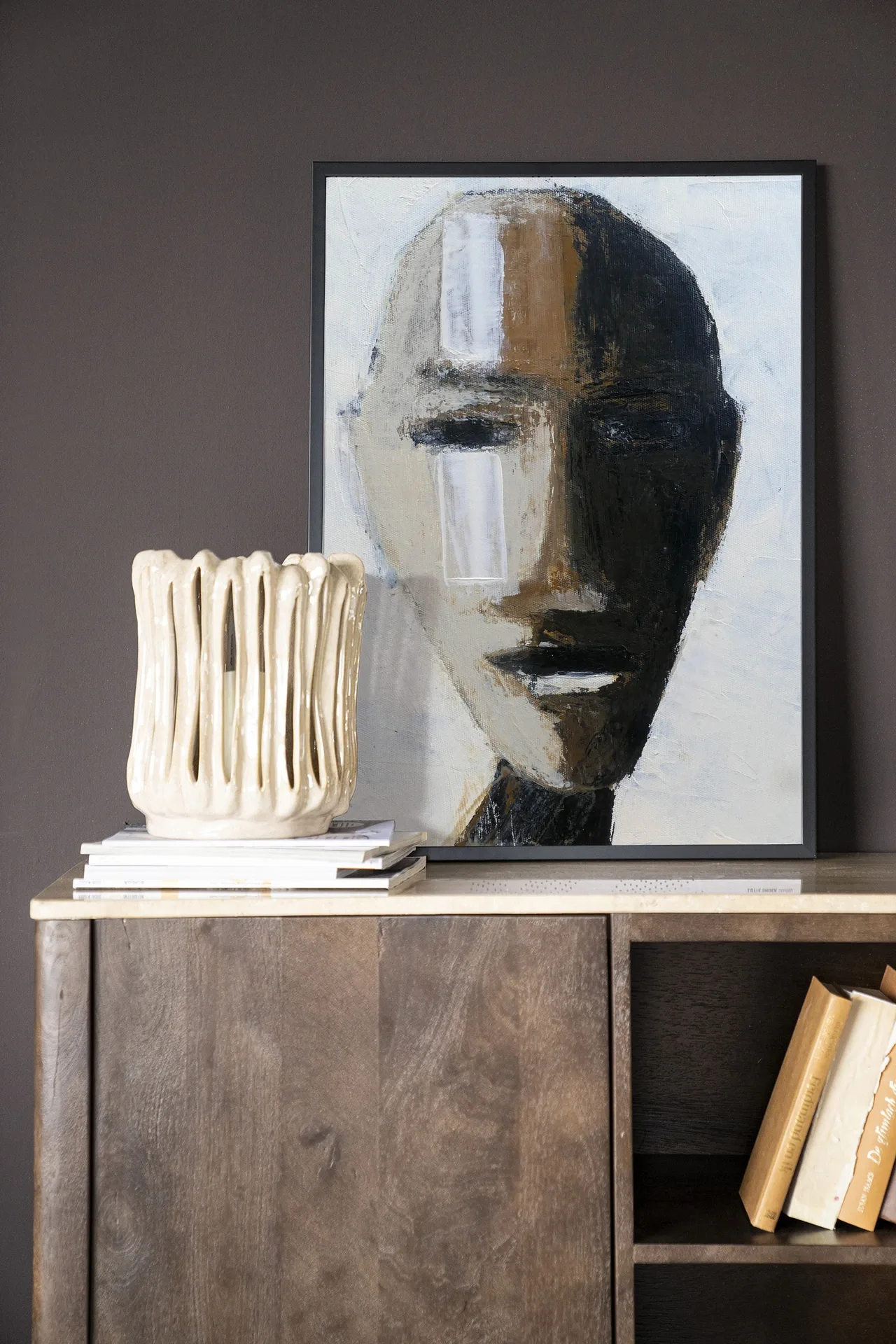 Wandteppich Head 2 - Urban Cotton in einer dunklen Umgebung auf einem Sideboard aus Holz mit Büchern