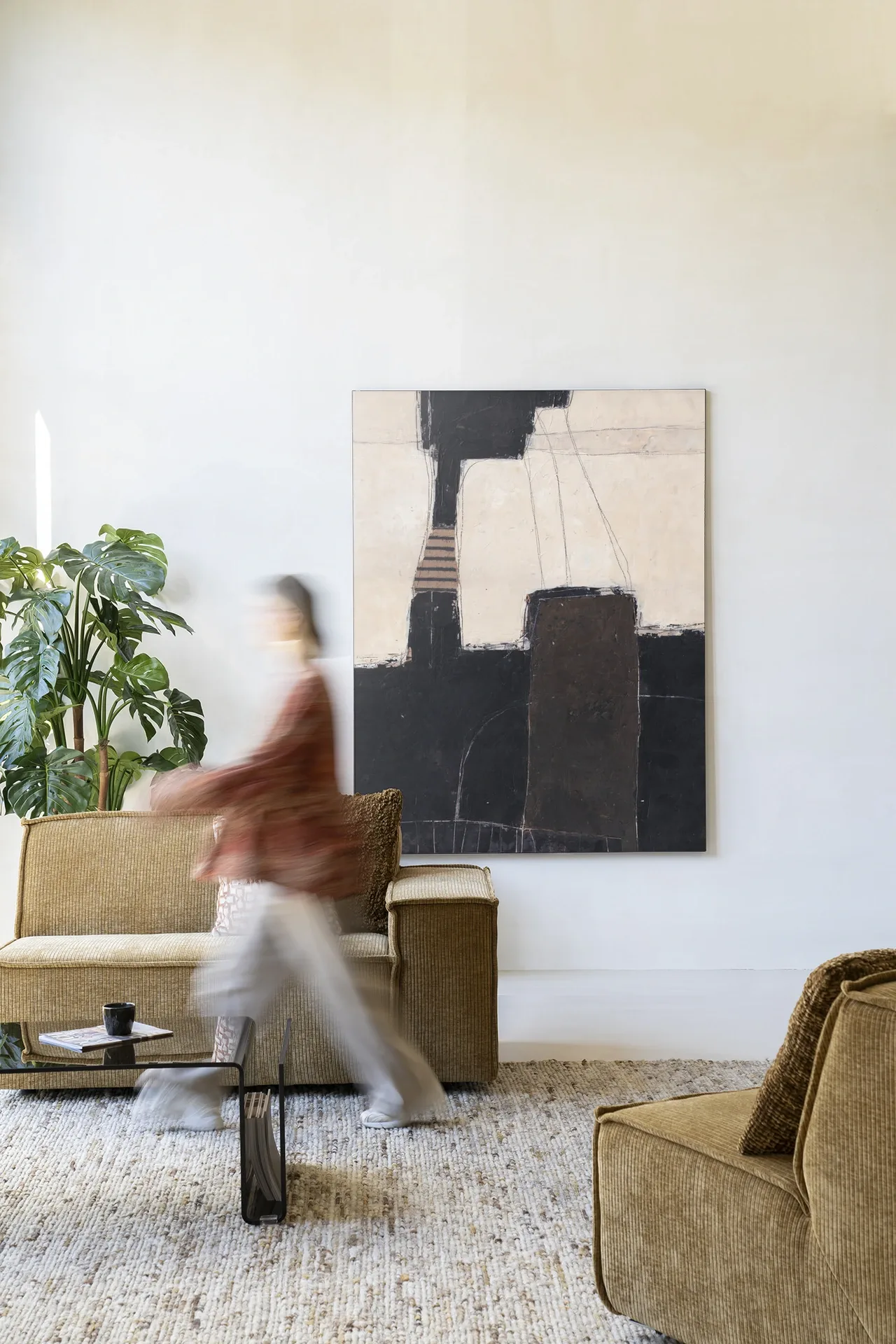 Wandteppich Abstract 2 - Urban Cotton hängt an einer weißen Wand in einem modernen Interieur mit einer Person in Bewegung