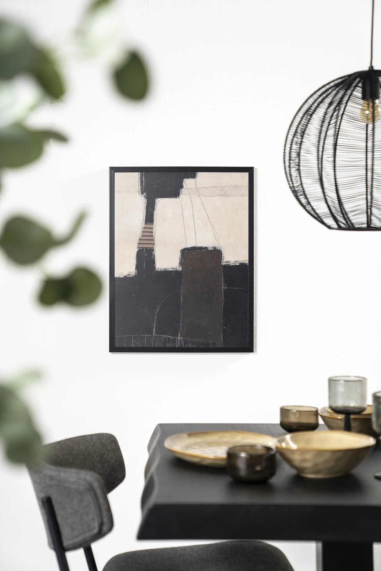 Wandteppich Abstract 2 - Urban Cotton hängt an einer weißen Wand über einem schwarzen Tisch mit goldenen Schalen