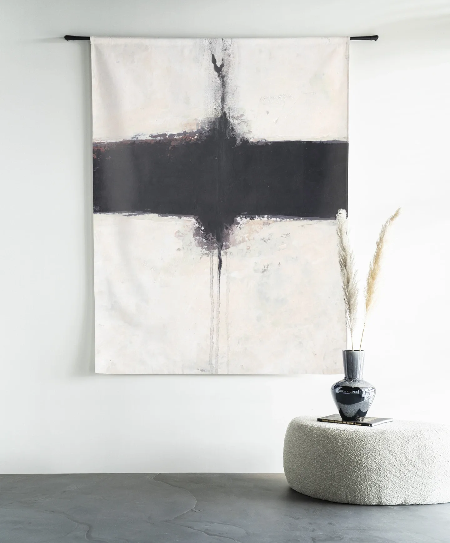 Wandteppich Abstract 3 - Urban Cotton hängt an einer schwarzen Stange über einem Hocker mit einer Vase und Pampasgras