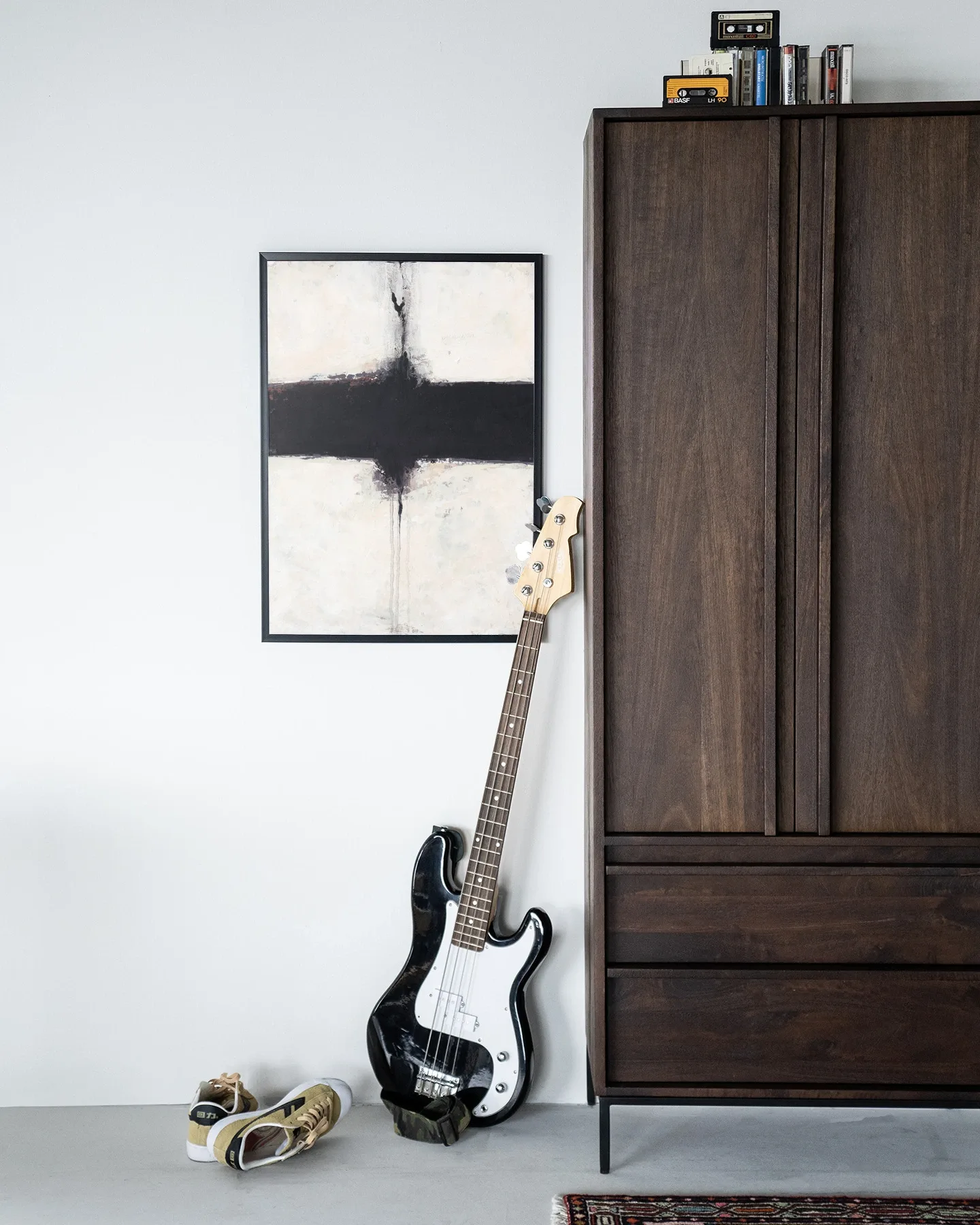 Wandteppich Abstract 3 - Urban Cotton hängt an einer weißen Wand neben einem dunkelbraunen Schrank mit einer Bassgitarre davor