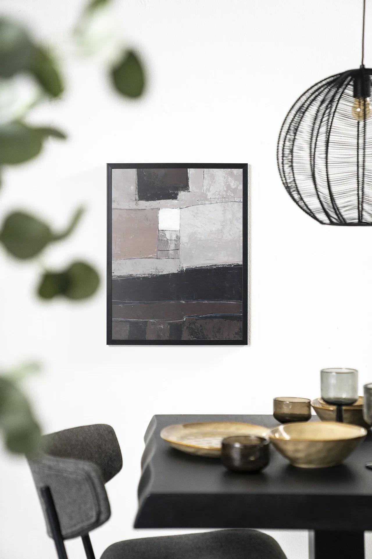 Wandteppich Abstract 4 - Urban Cotton hängt an einer weißen Wand über einem schwarzen Tisch