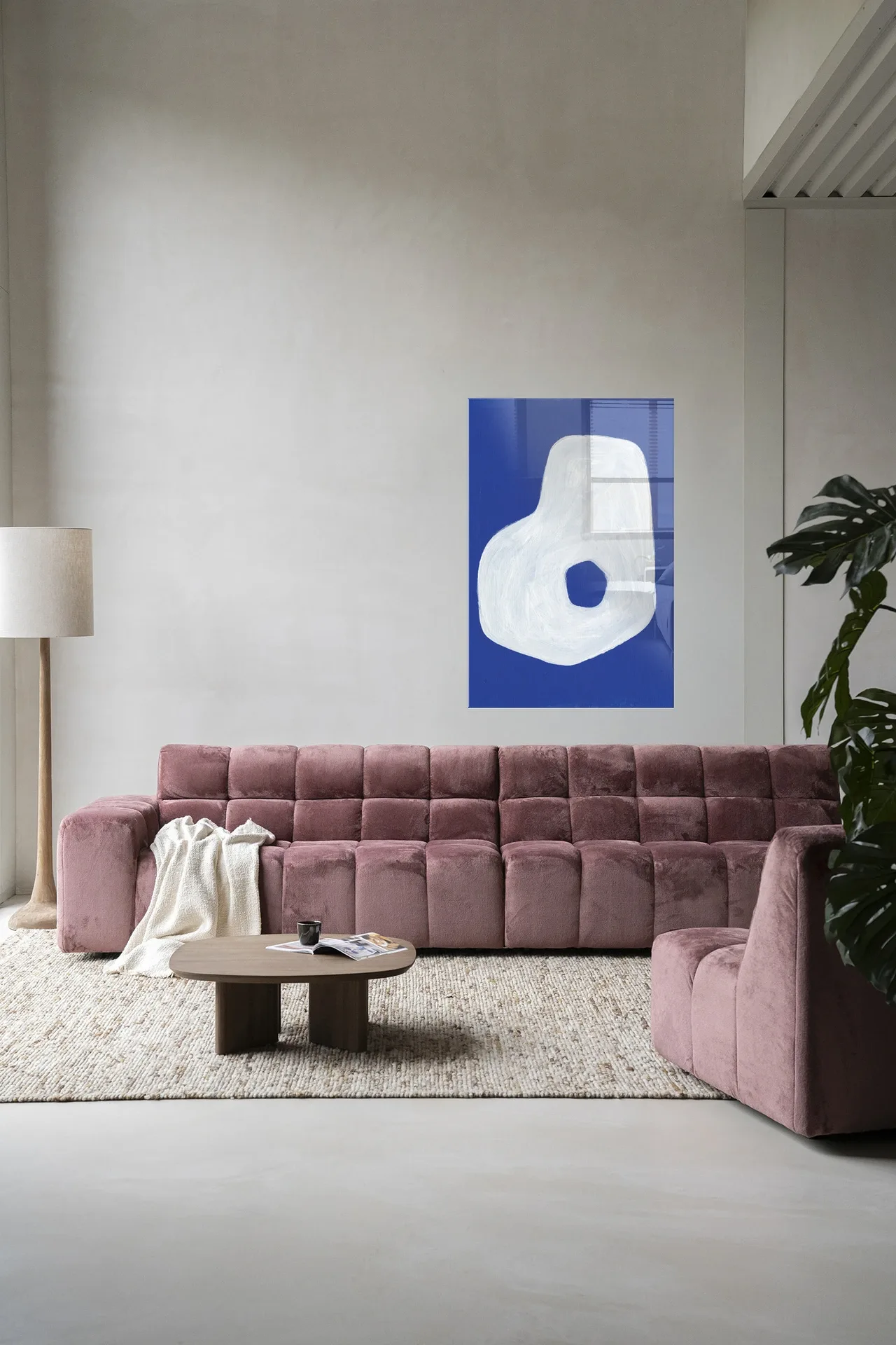 Wandkleed Spook - Urban Cotton hangt aan een lichte wand boven een roze bank in een woonkamer