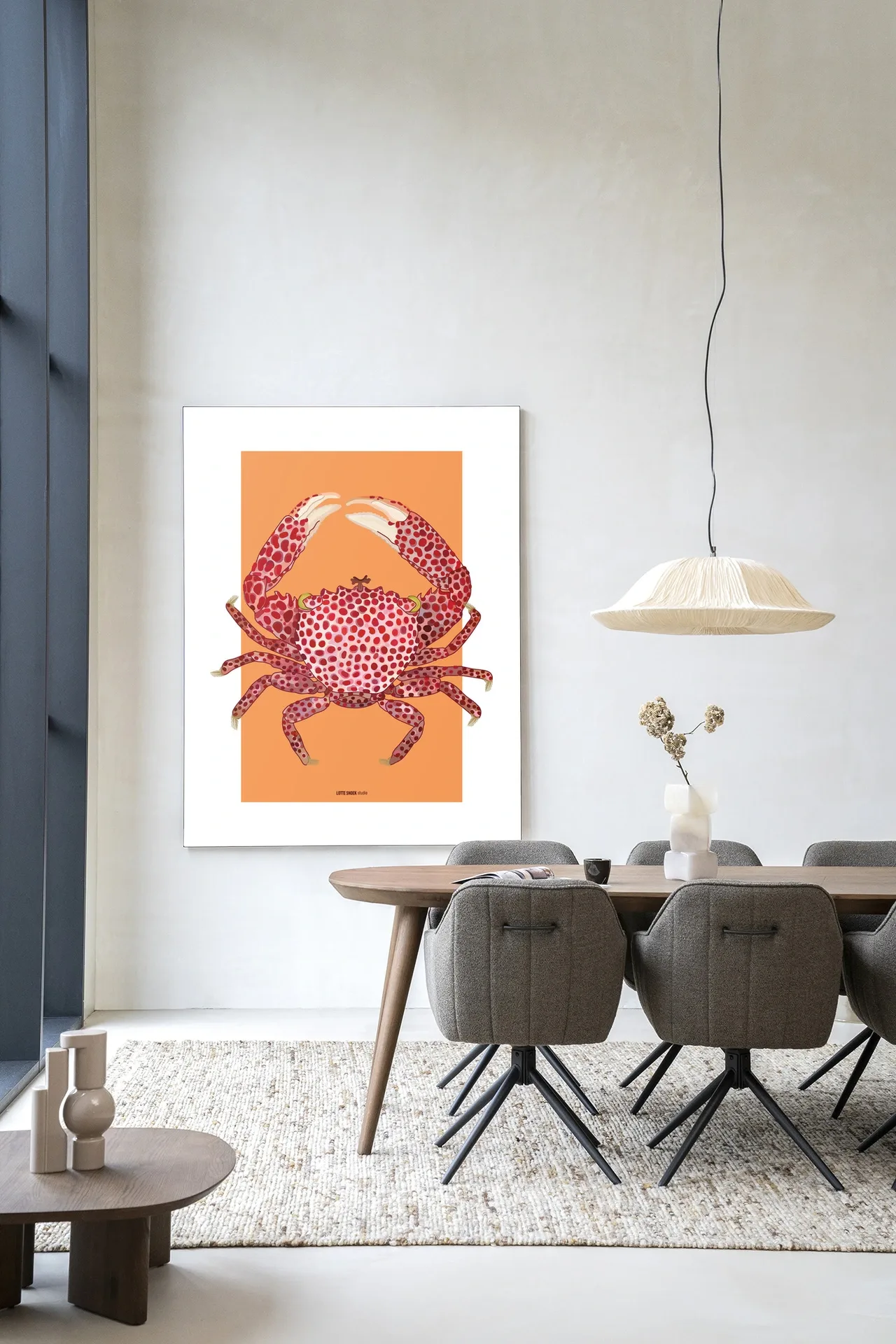 Der Art Print Trapezia - Urban Cotton hängt an einer weißen Wand über einem Holzesstisch mit Stühlen
