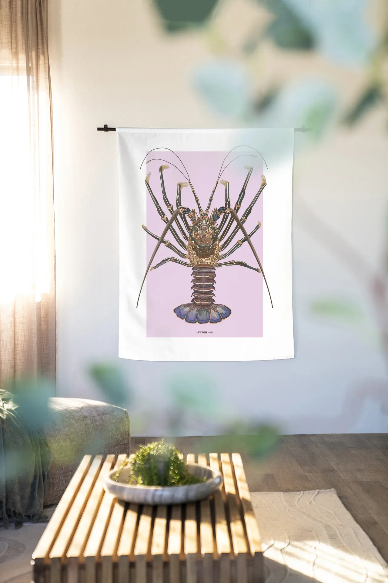 Wandteppich Langosta - Urban Cotton in einem hellen Wohnzimmer mit Couchtisch und Pflanze