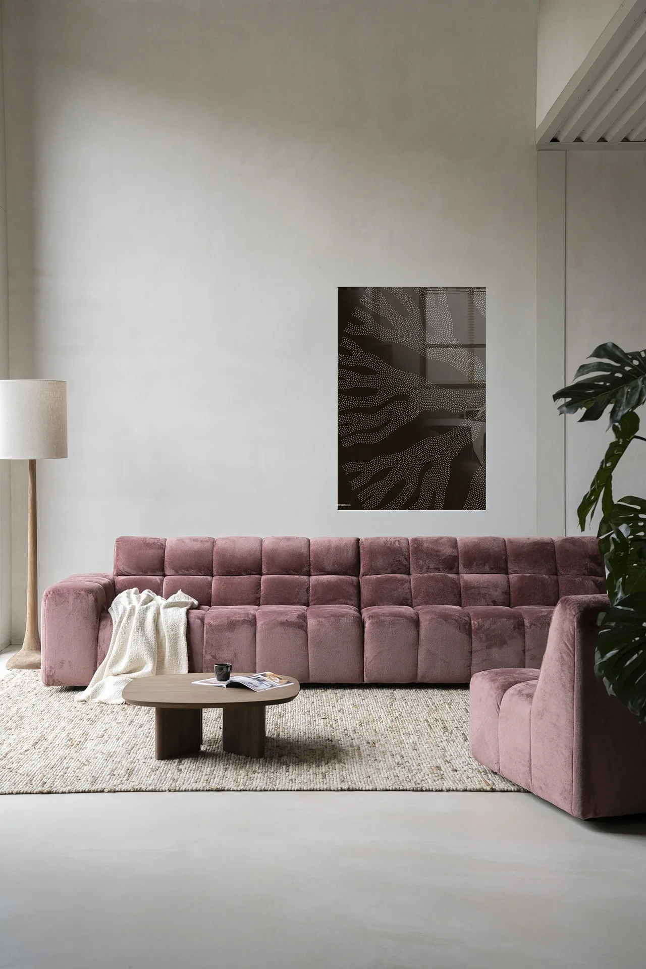 Wandteppich Circle Dark von Urban Cotton hängt über einem rosa Sofa in einem modernen Wohnzimmer