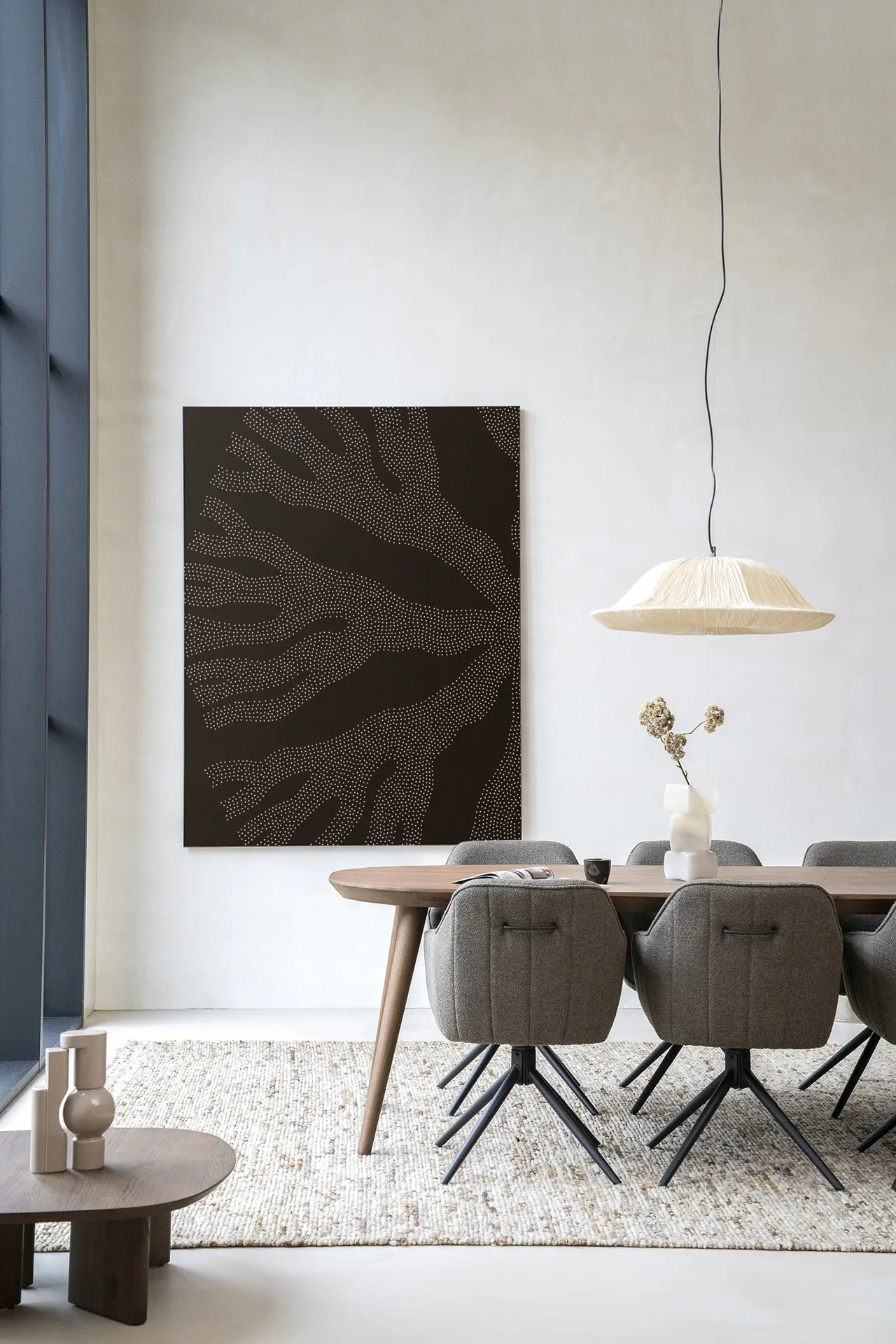 Wandteppich Circle Dark - Urban Cotton hängt an einer weißen Wand über einem Esstisch
