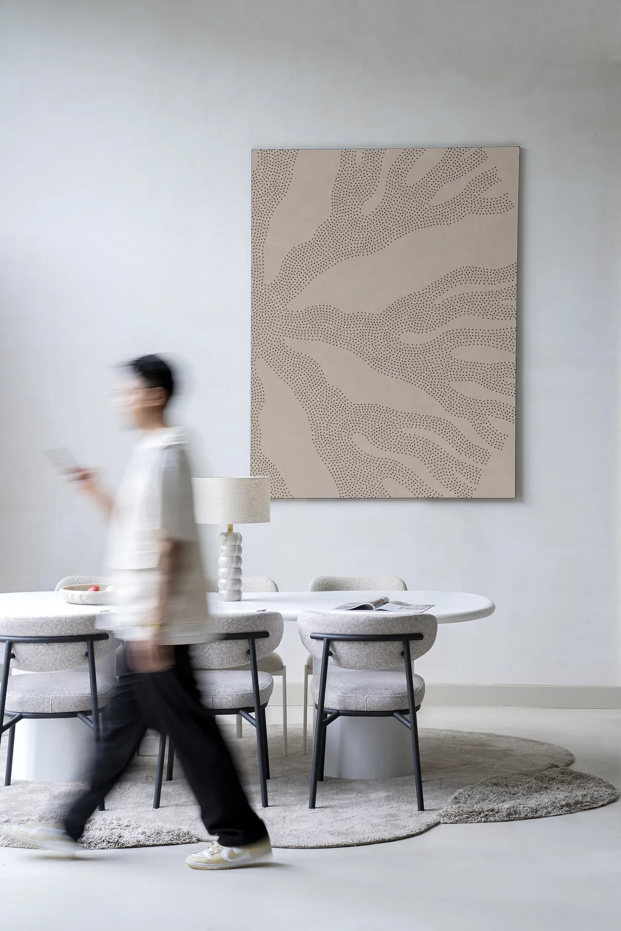 Wandteppich Circle Light - Urban Cotton hängt an einer hellen Wand in einem modernen Interieur mit Esstisch