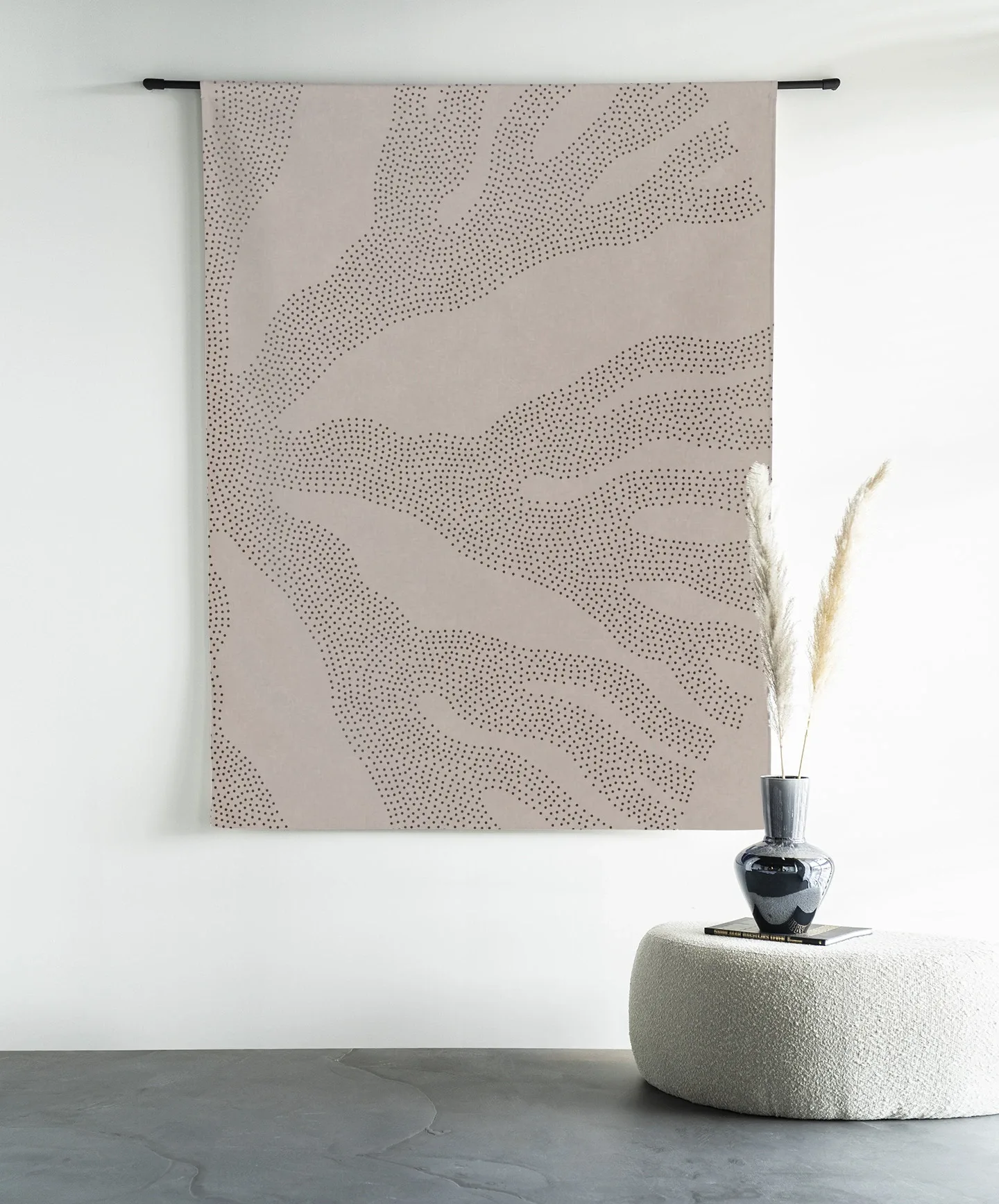 Wandteppich Circle Light - Urban Cotton hängt an einer schwarzen Stange in einem modernen Ambiente mit einem Hocker und einer Vase