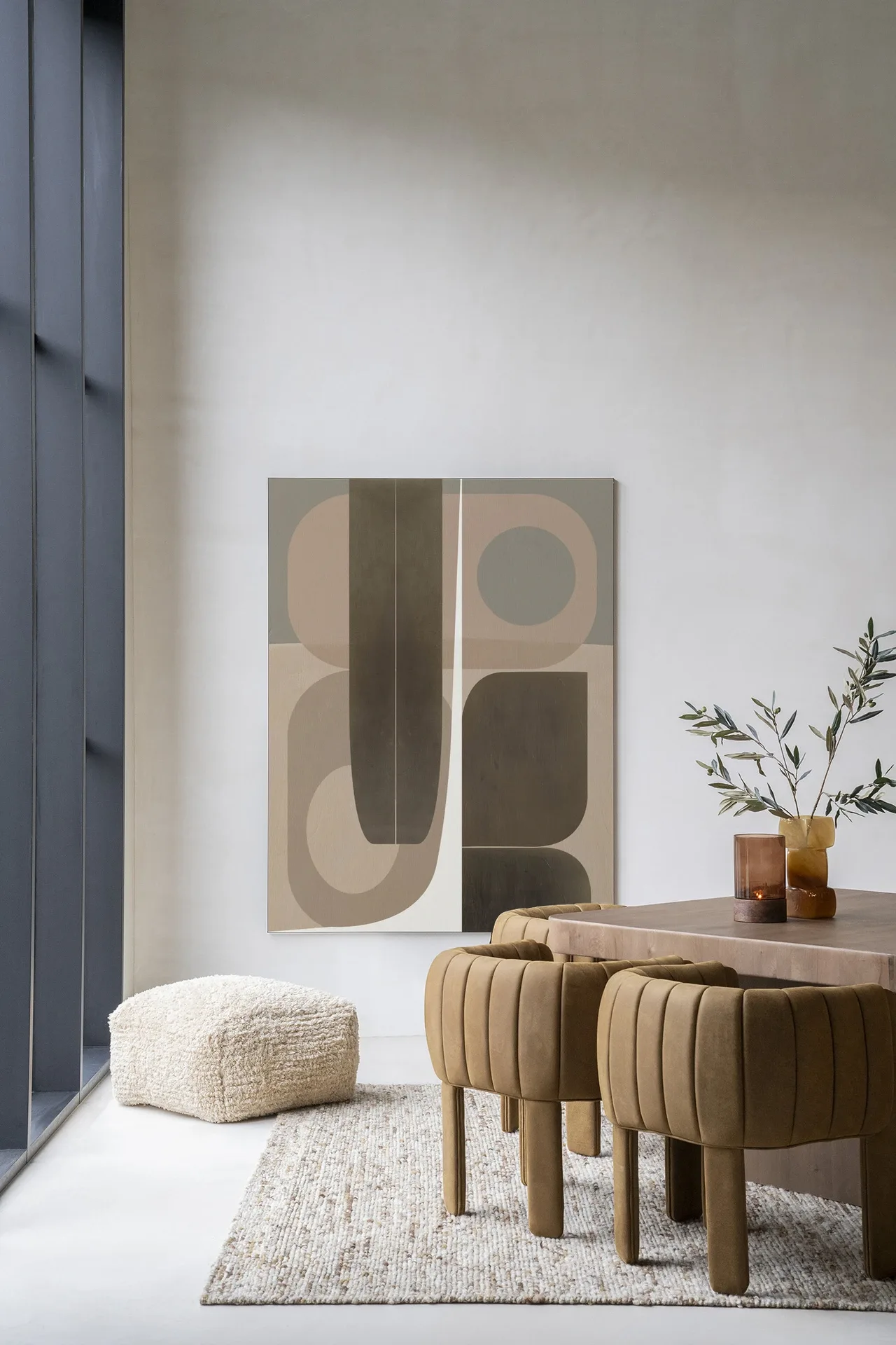 Wandteppich Delicate von Urban Cotton hängt über einem beigen Pouf in einem modernen Esszimmer mit Holztisch und Stühlen