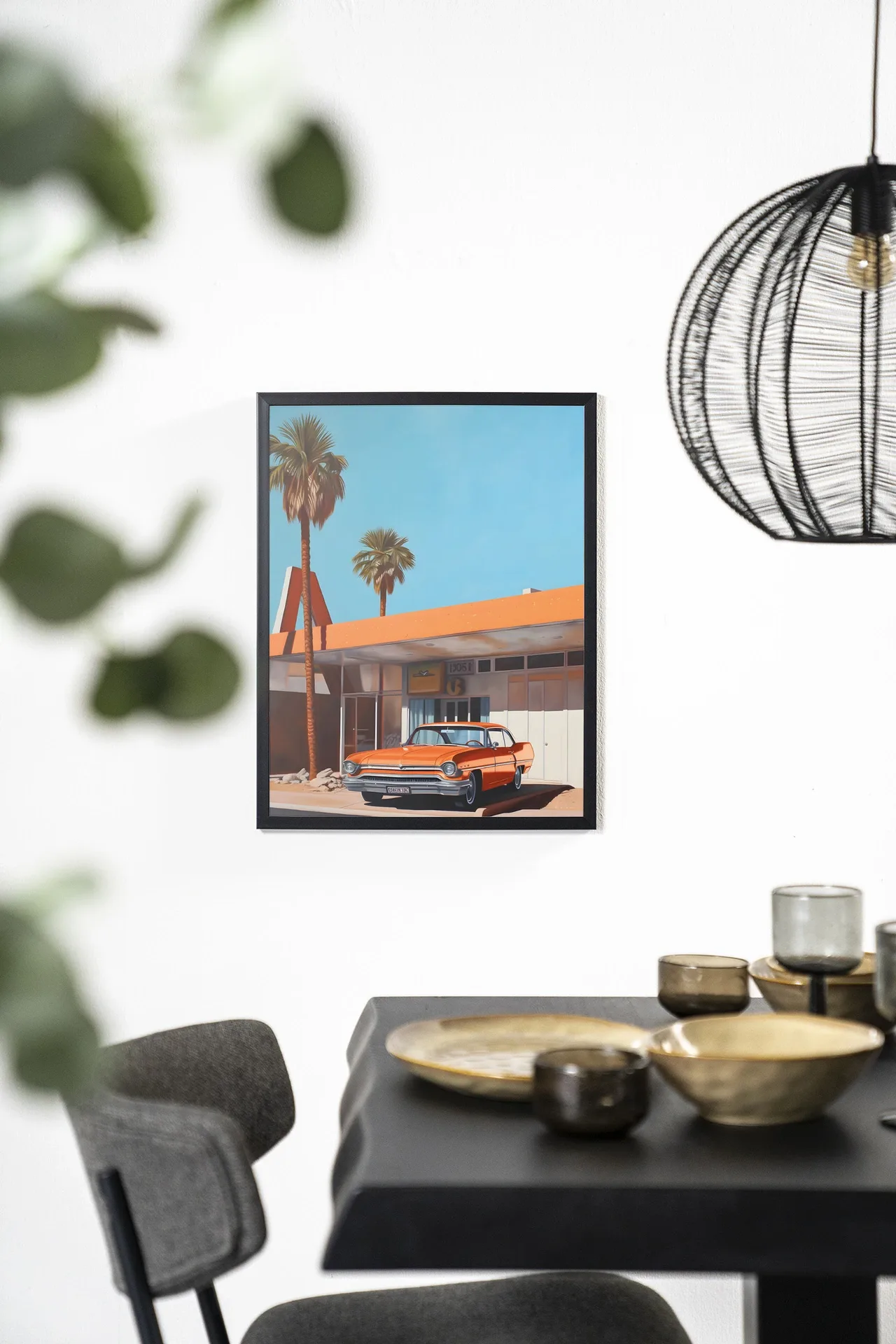 Wandteppich Sonny - Urban Cotton hängt an einer weißen Wand über einem schwarzen Tisch mit goldenen Schalen
