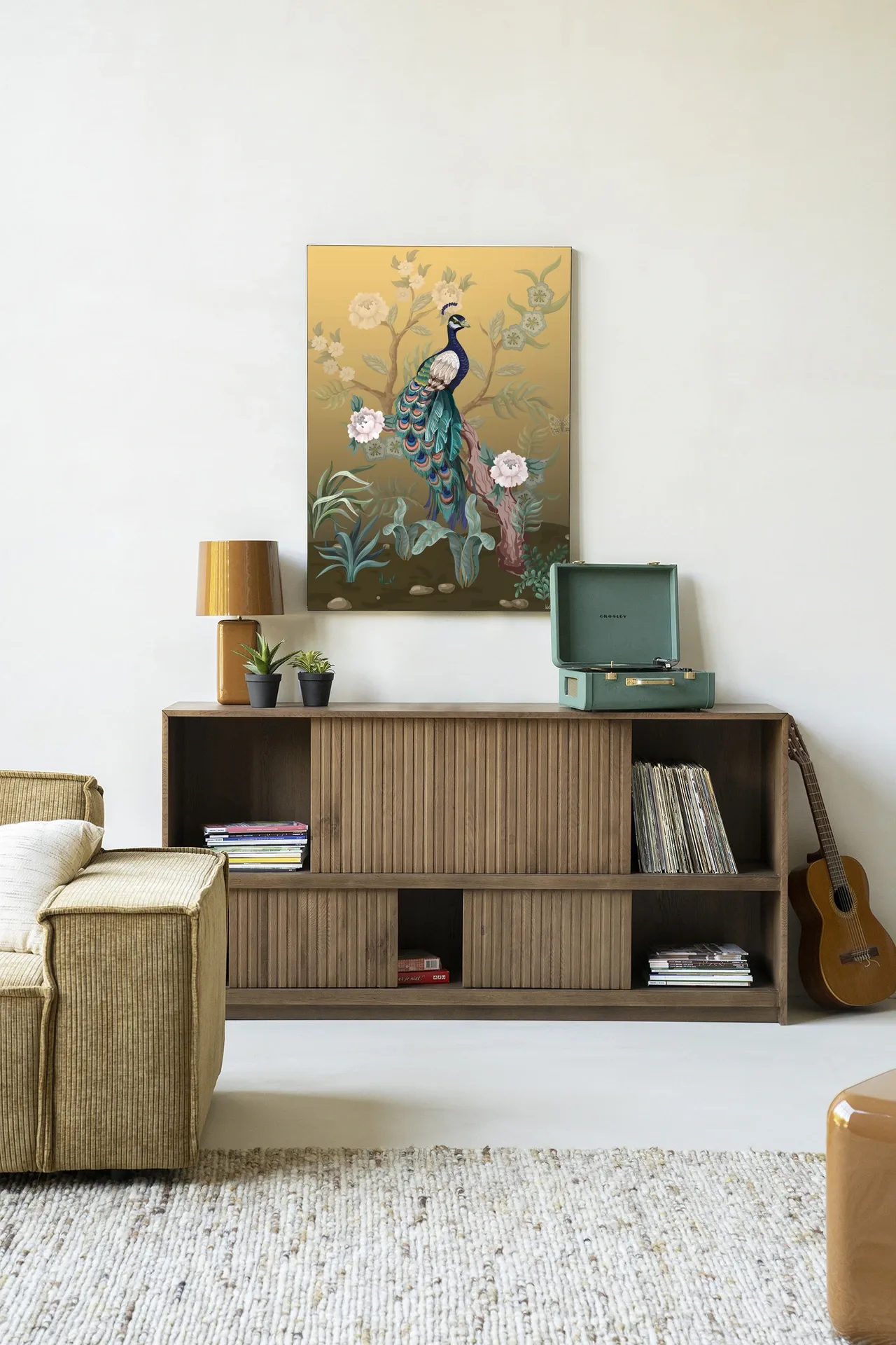 Wandkleed Peacock - Urban Cotton hangend boven een houten dressoir in een lichte woonkamer