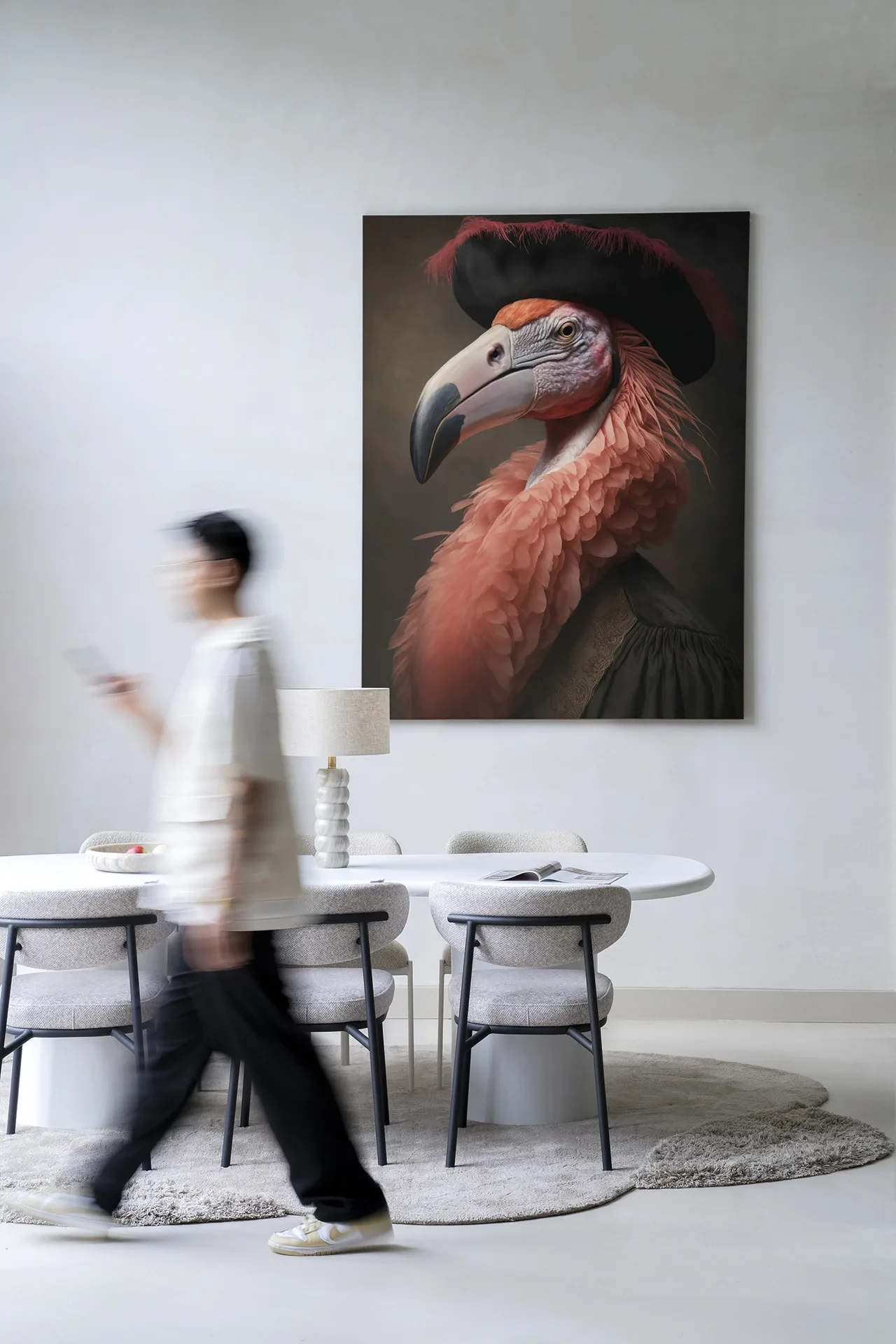 Wandkleed Flamingo - Urban Cotton hangend aan een witte muur in een modern interieur met een persoon in beweging