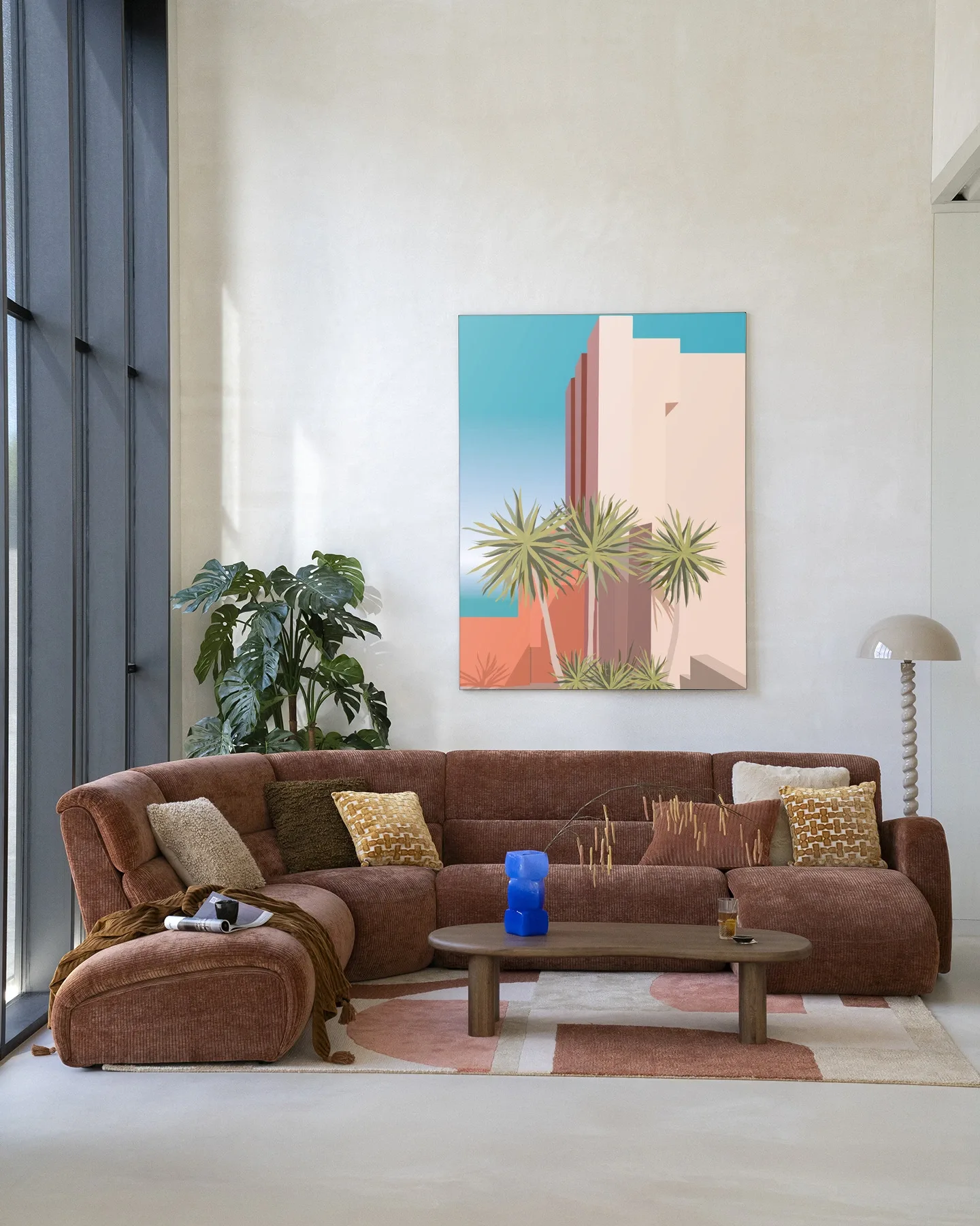 Wandkleed Tropical Place - Urban Cotton in een lichte woonkamer boven een bruine bank