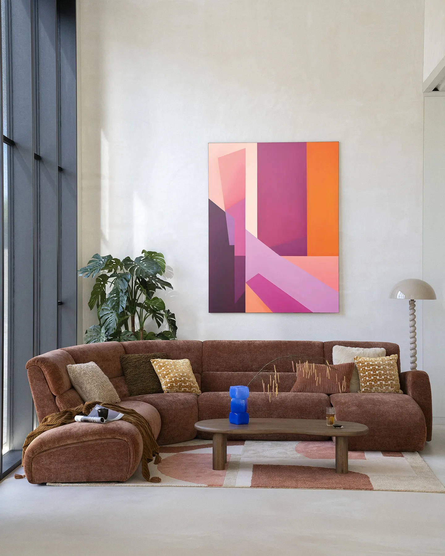 Wandkleed Folded Lines van Urban Cotton hangt boven een bruine hoekbank in een lichte woonkamer