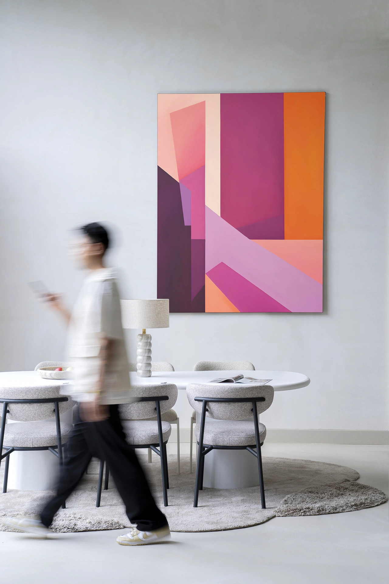 Wandkleed Folded Lines - Urban Cotton hangt aan een lichte muur boven een eettafel