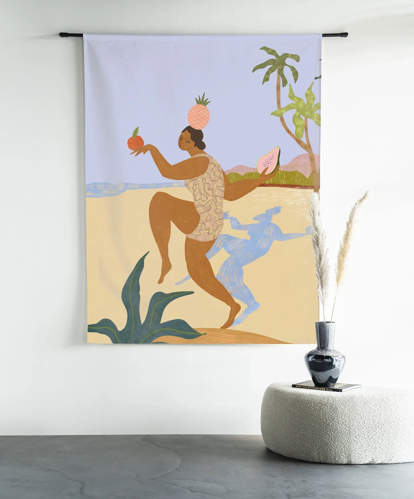 Wandkleed Balancing Act - Urban Cotton hangend aan een zwarte roede boven een poef met een vaas