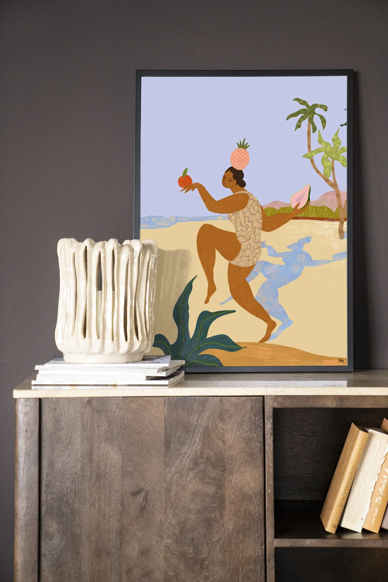 Wandkleed Balancing Act - Urban Cotton ingelijst aan een donkergrijze muur boven een houten kast