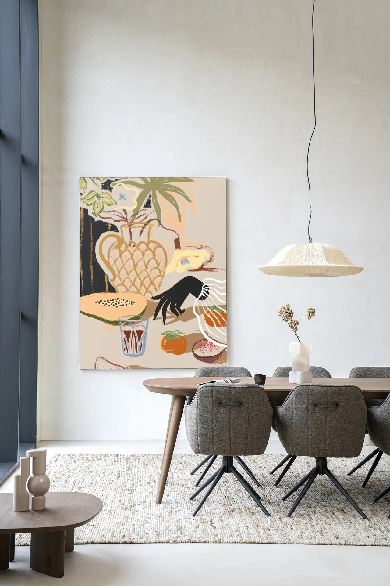 Een modern Wandkleed Fruitful Spread - Urban Cotton hangt in een lichte eetkamer boven een houten eettafel met stoelen