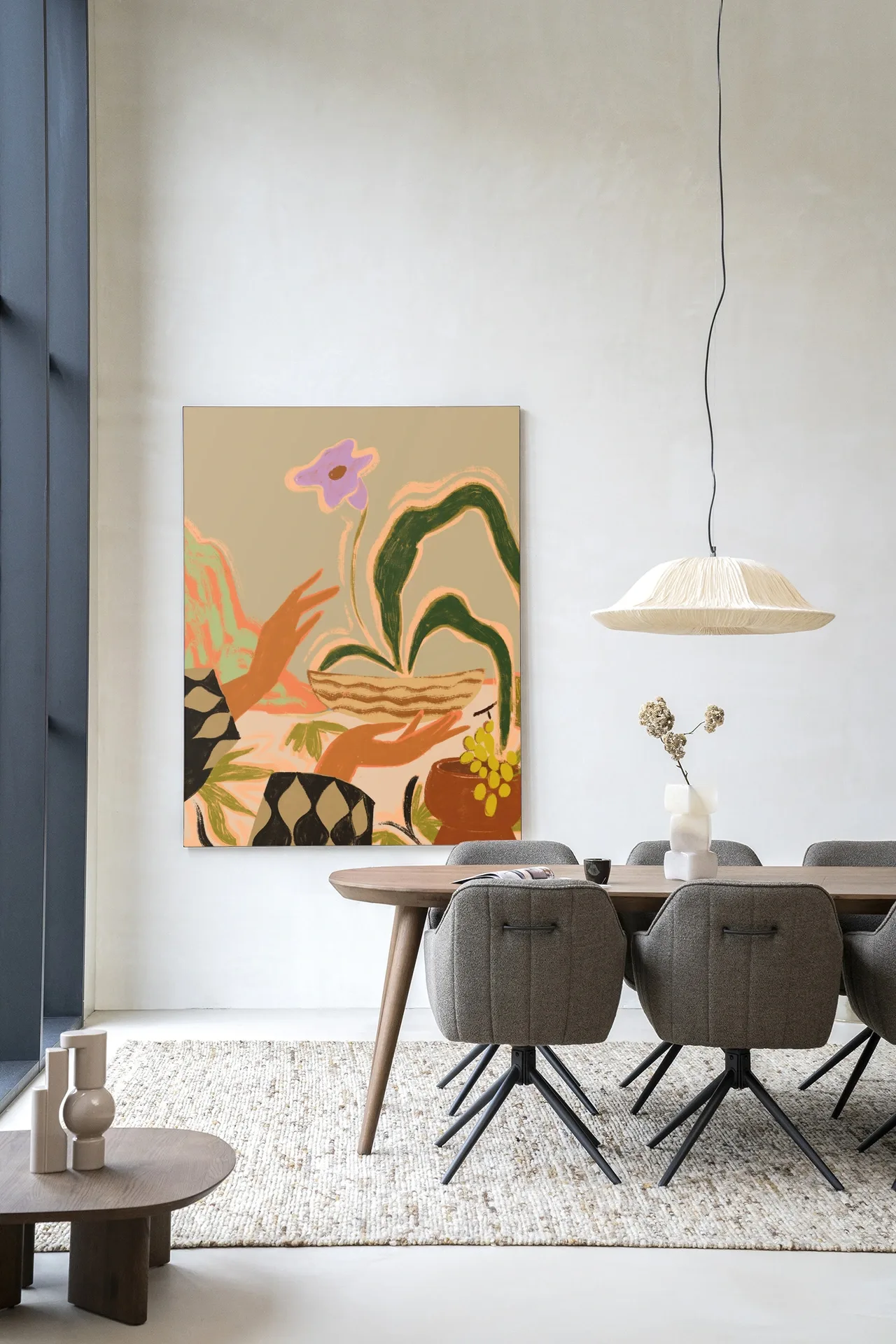 Wandkleed The Power of One hangt aan een lichte muur boven een eettafel met stoelen - Urban Cotton