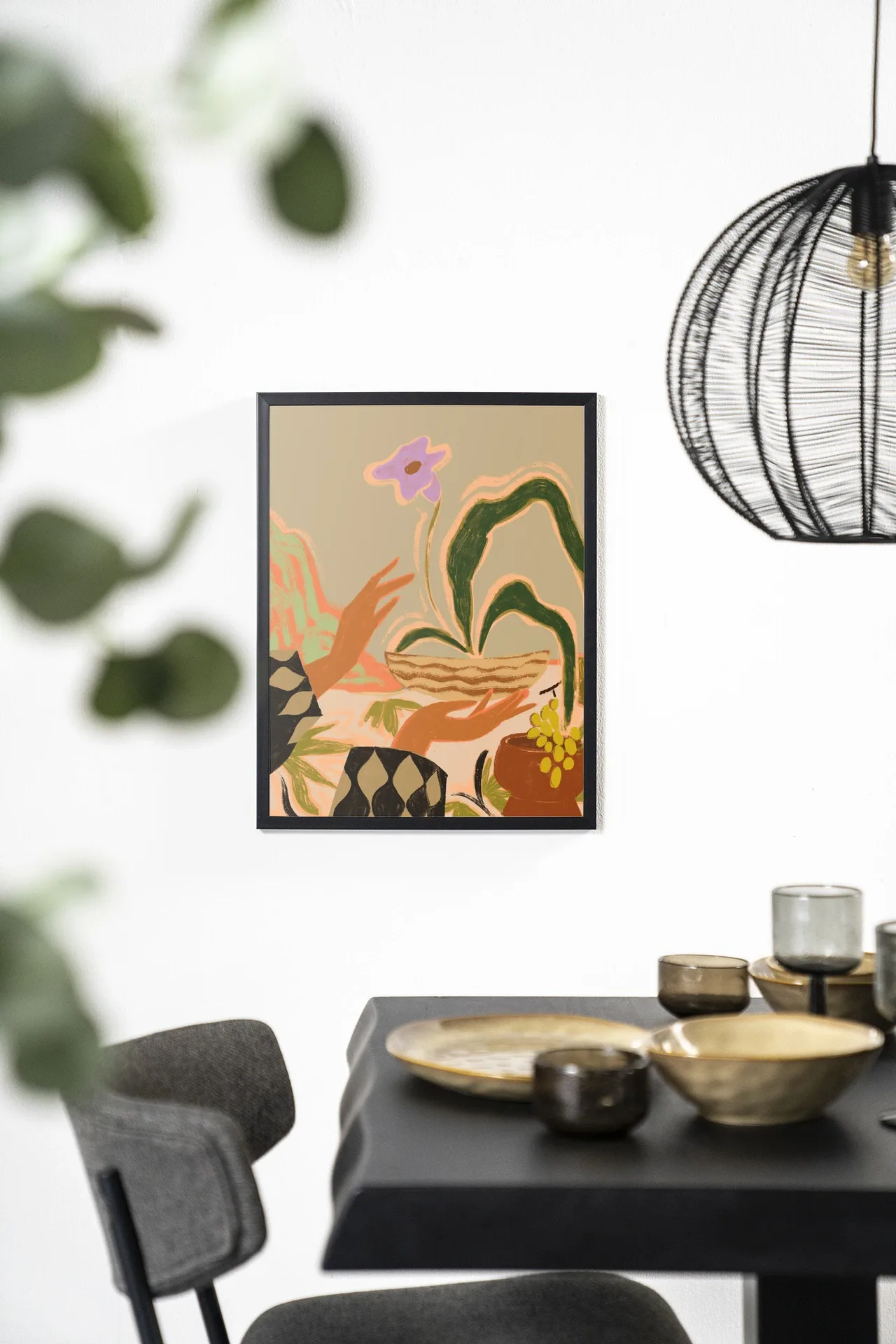 Wandkleed The Power of One aan een witte muur boven een zwarte eettafel met gouden schalen - Urban Cotton